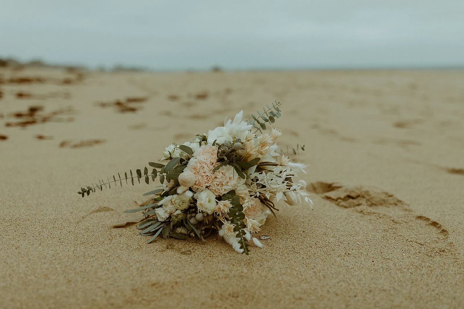 floral bouquet lying in sand