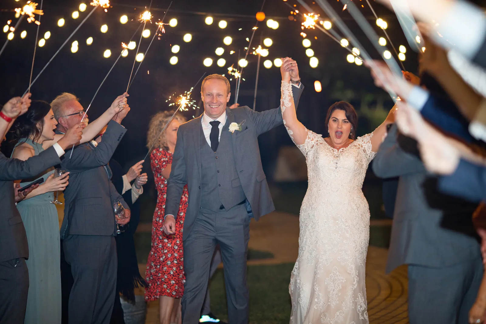 Bride and groom celebrate as guests light sparklers