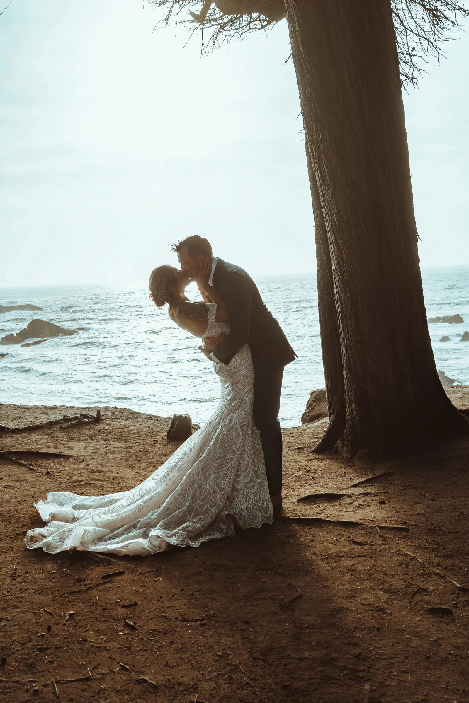 Bride and groom kissing near water