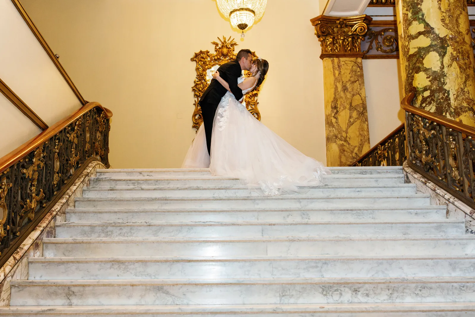 Newlyweds kissing on staircase