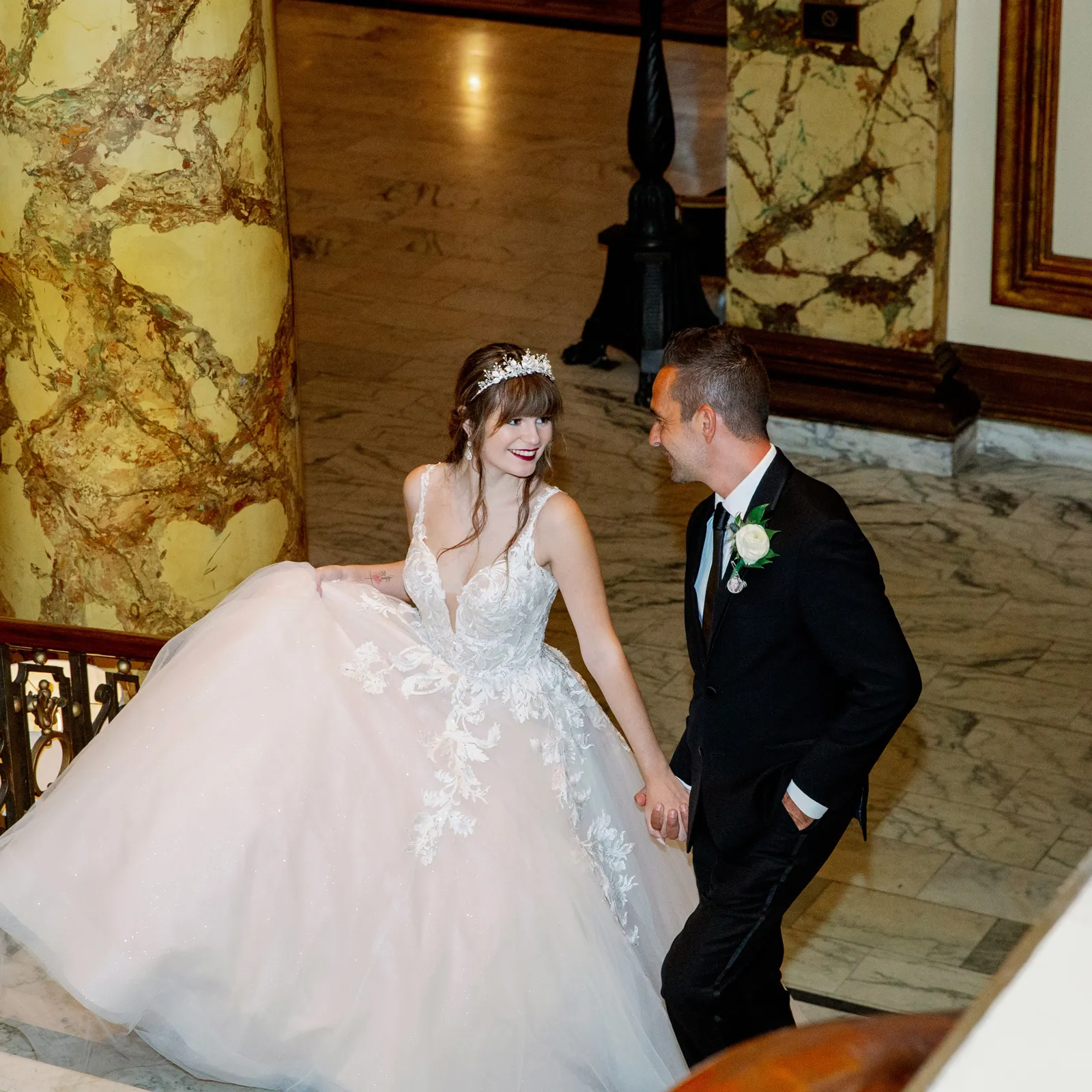 Bride and groom going up staircase