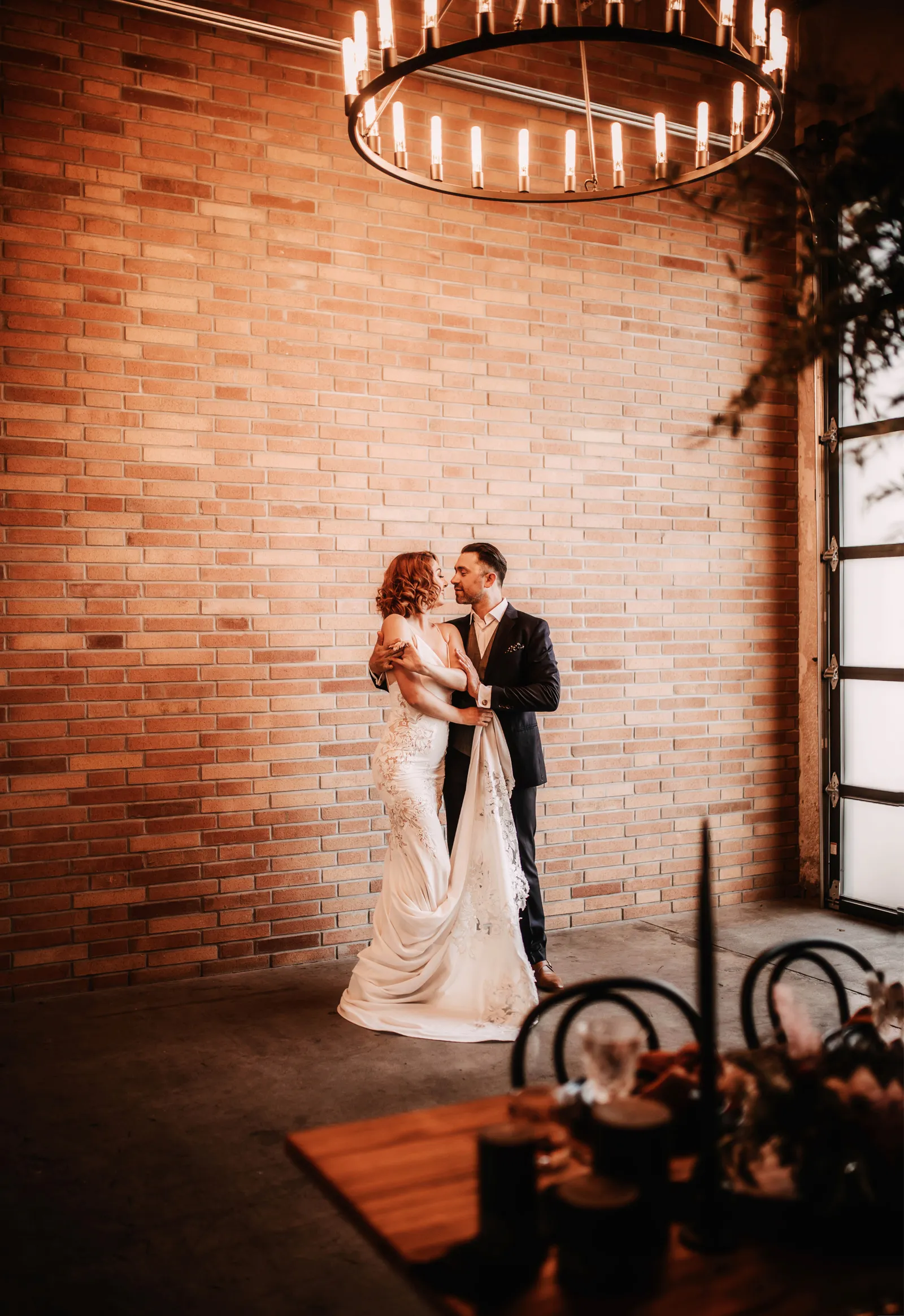 Newlyweds dancing under chandalier