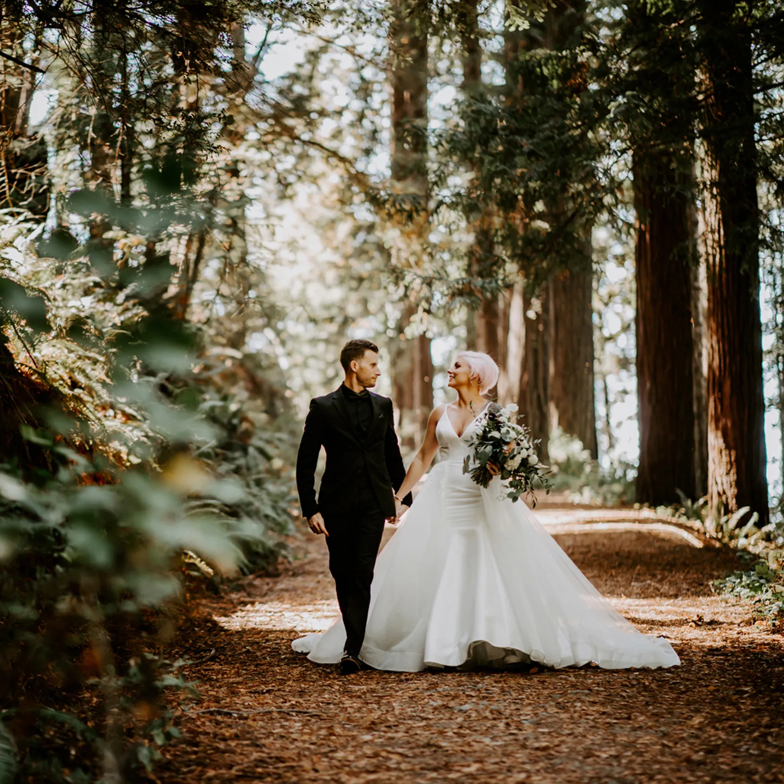 Bride and groom walking in forest