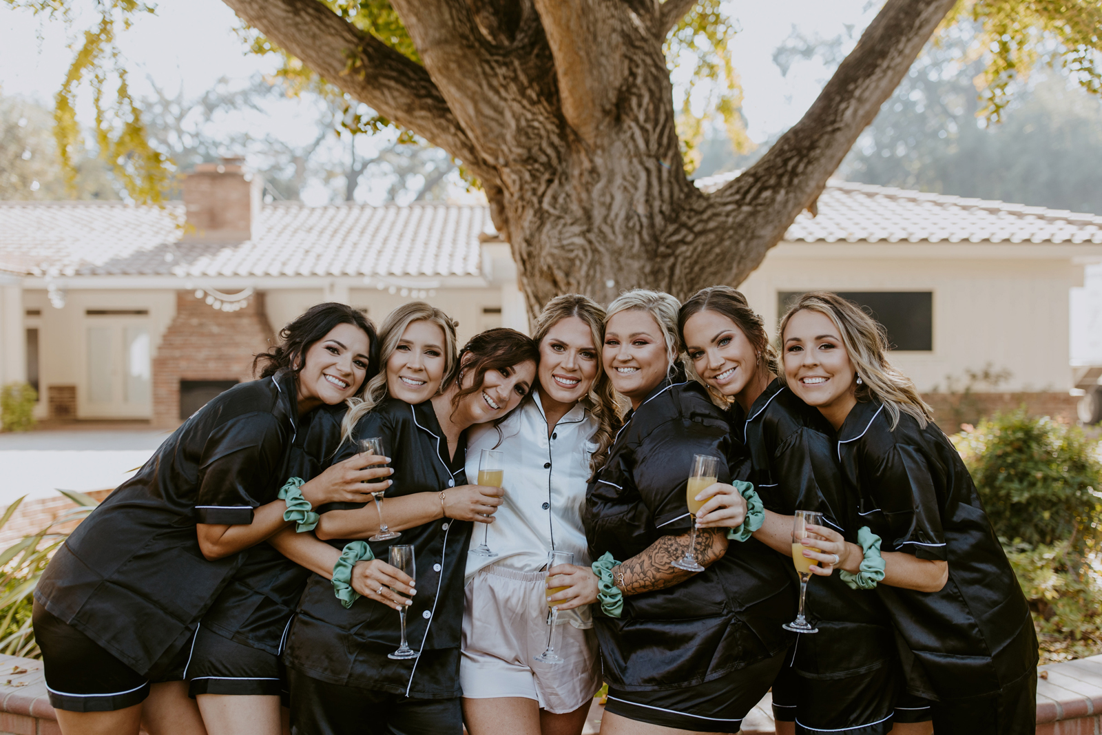 Bride and bridesmaids taking photos outside in pajamas