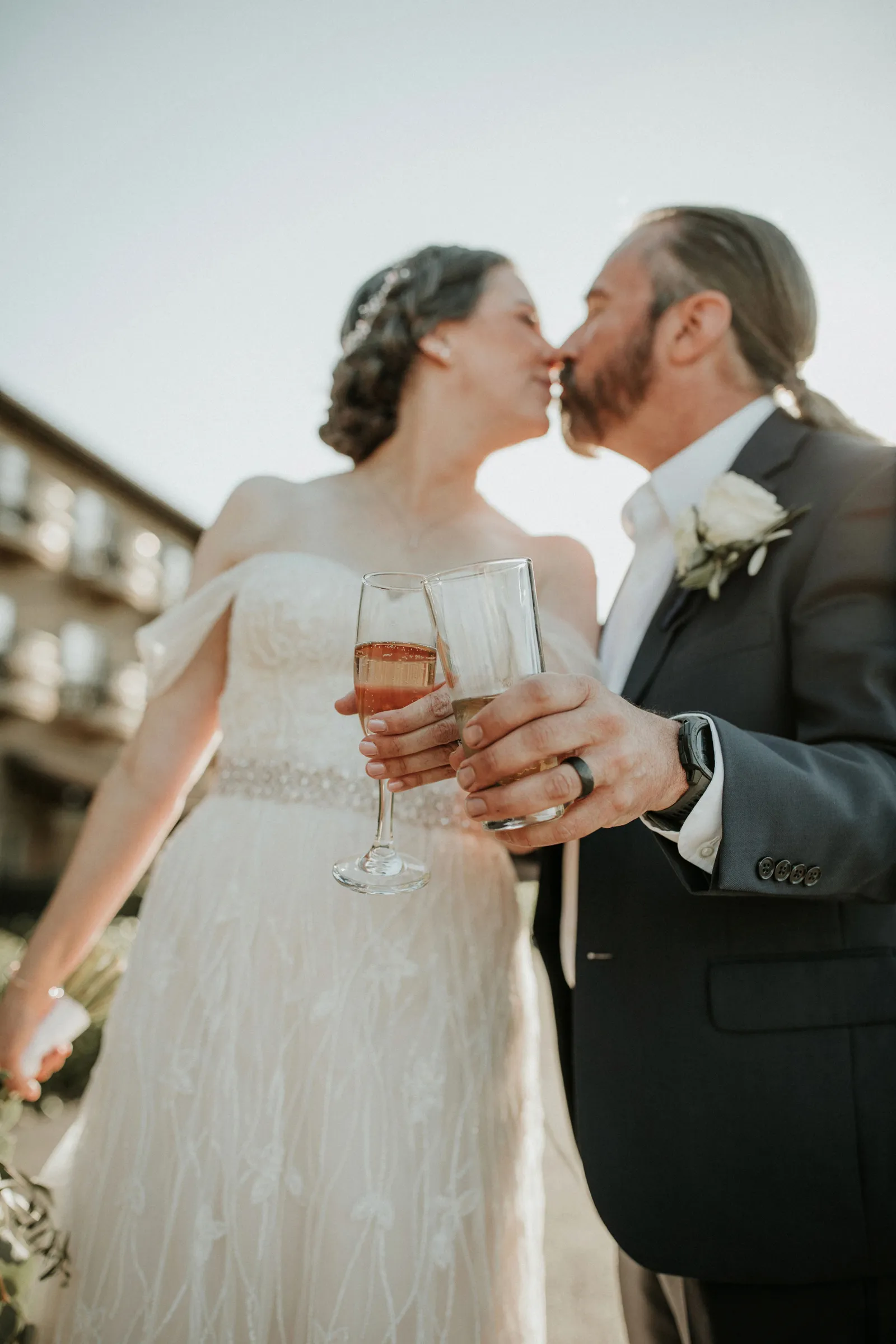 Bride and groom cheersing and kissing