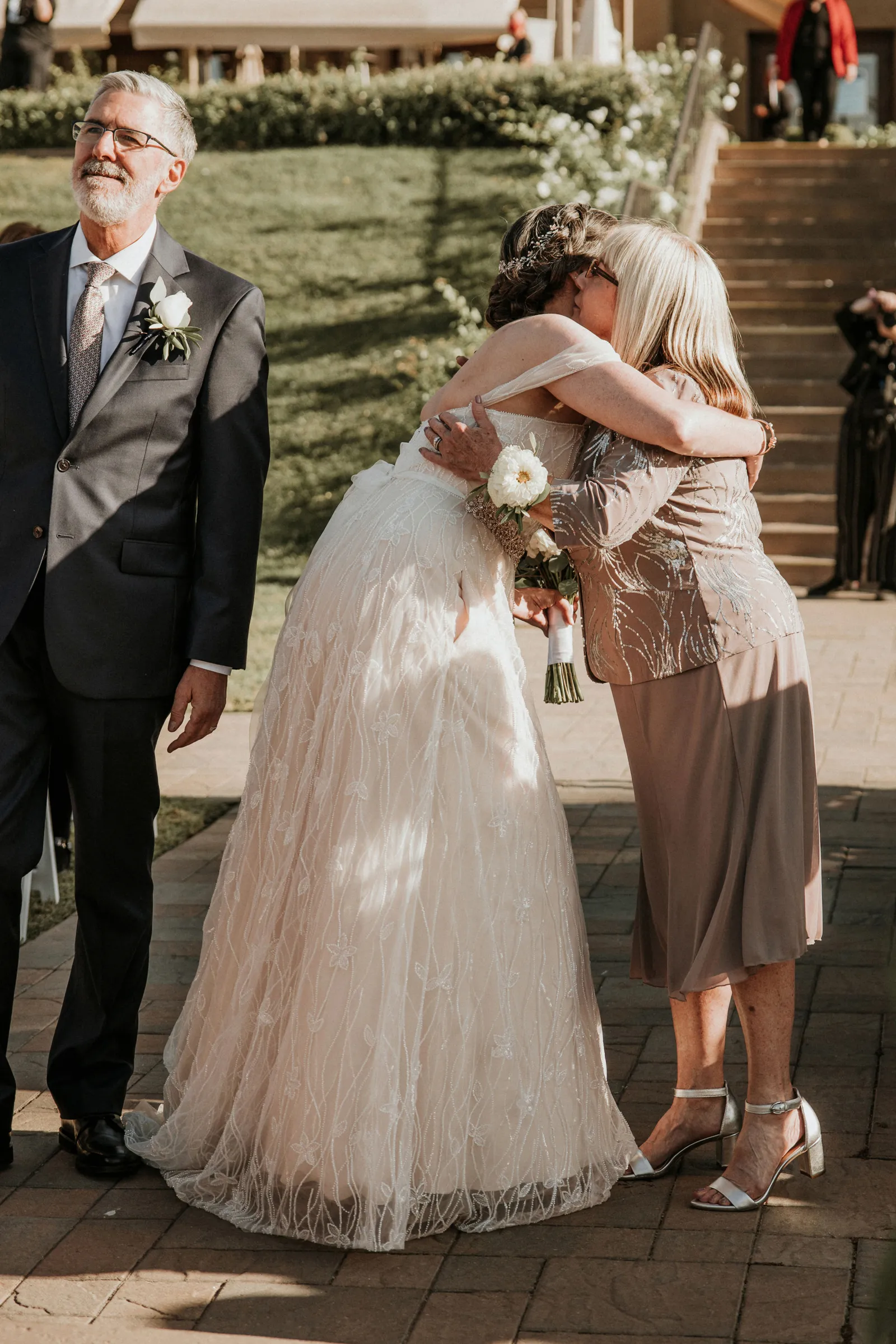 Bride hugging her mother on the aisle