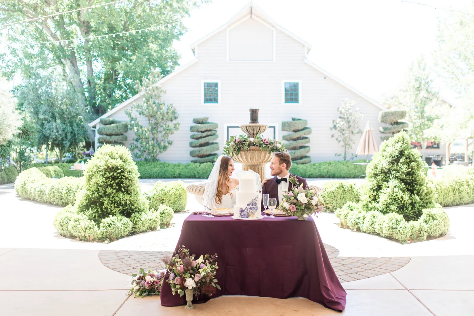 Bride and Groom sitting at a purple table