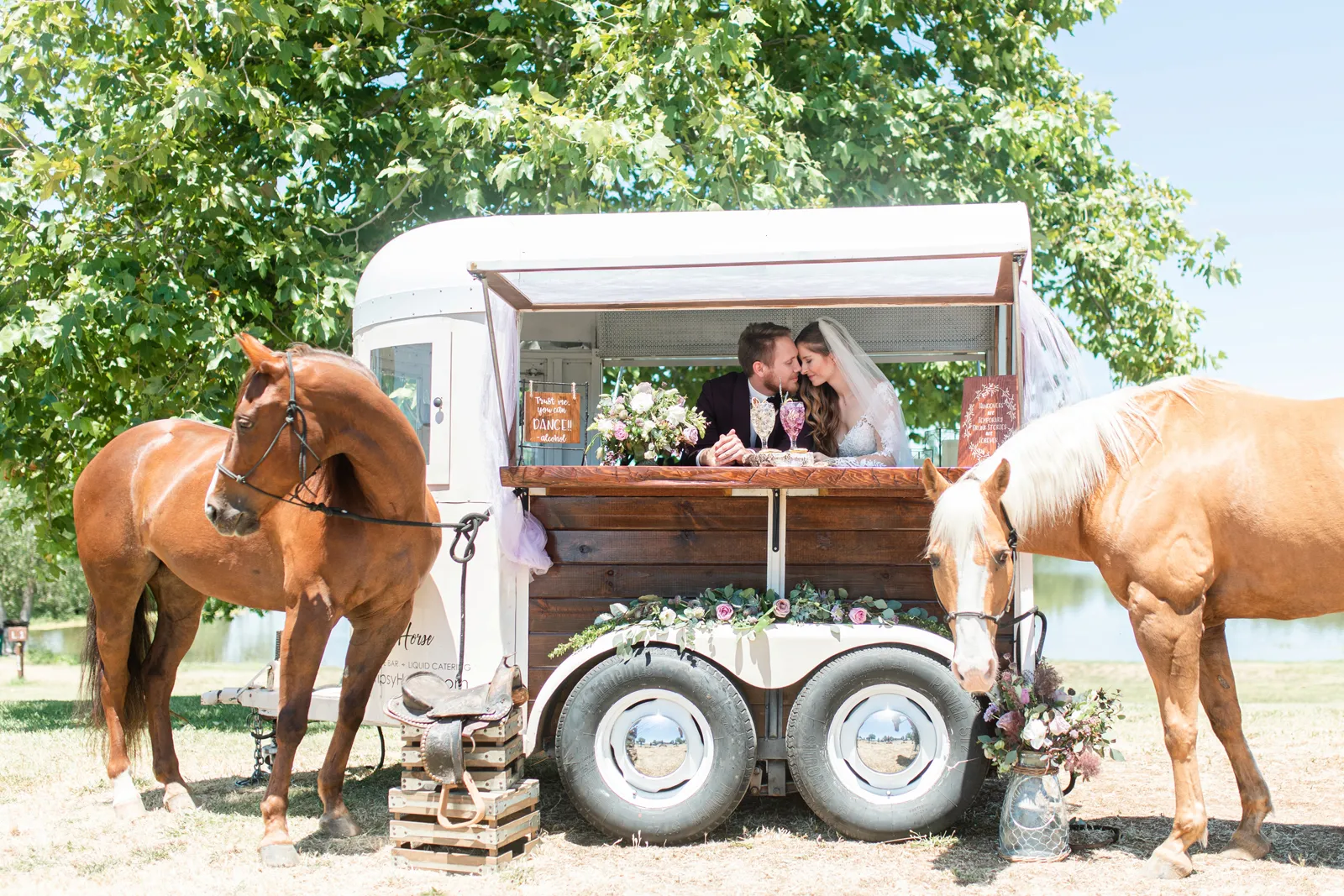 Bride and groom kissing in a moving bar cart with horses.