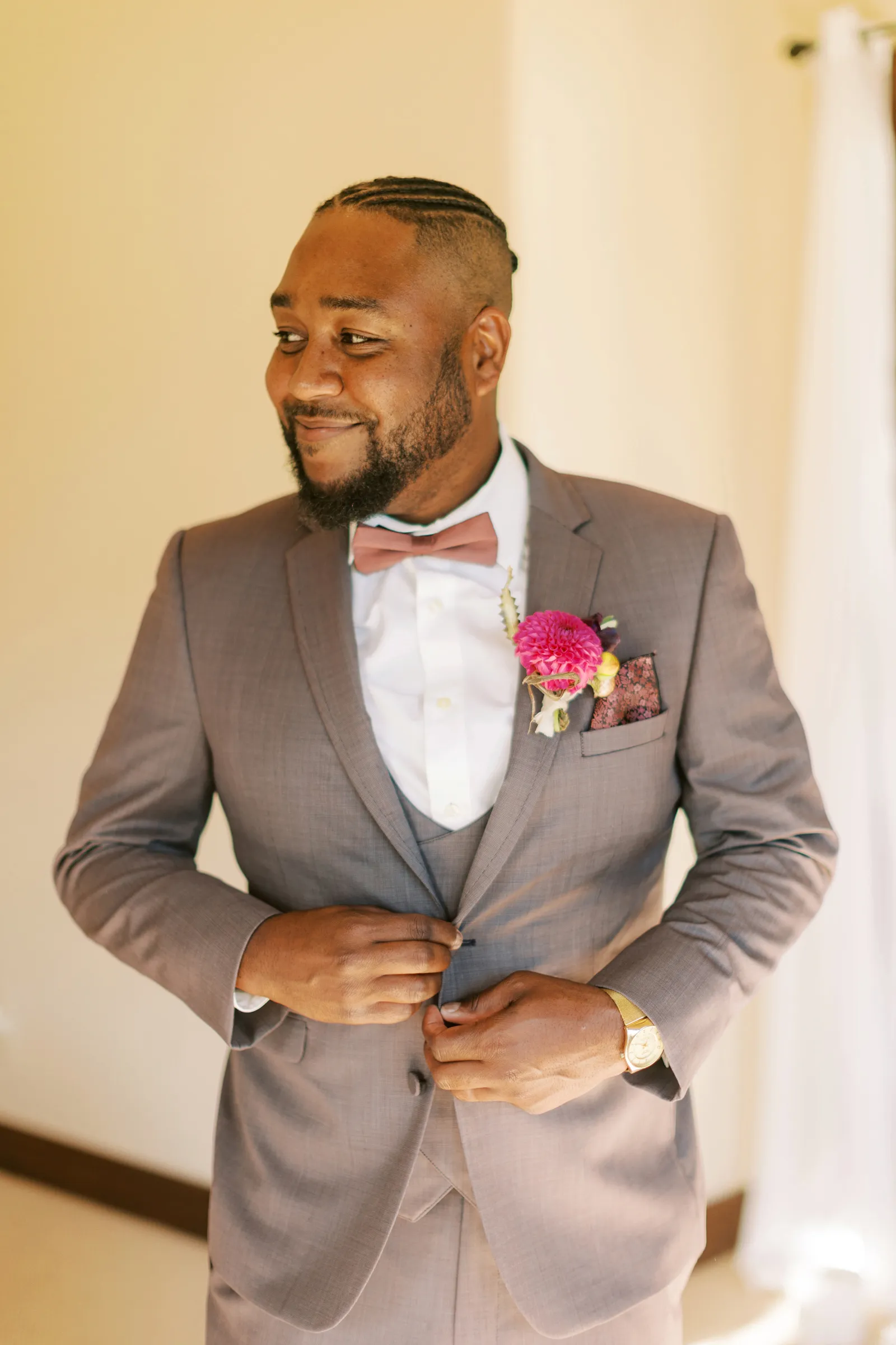 Groom fixing his suit and smiling