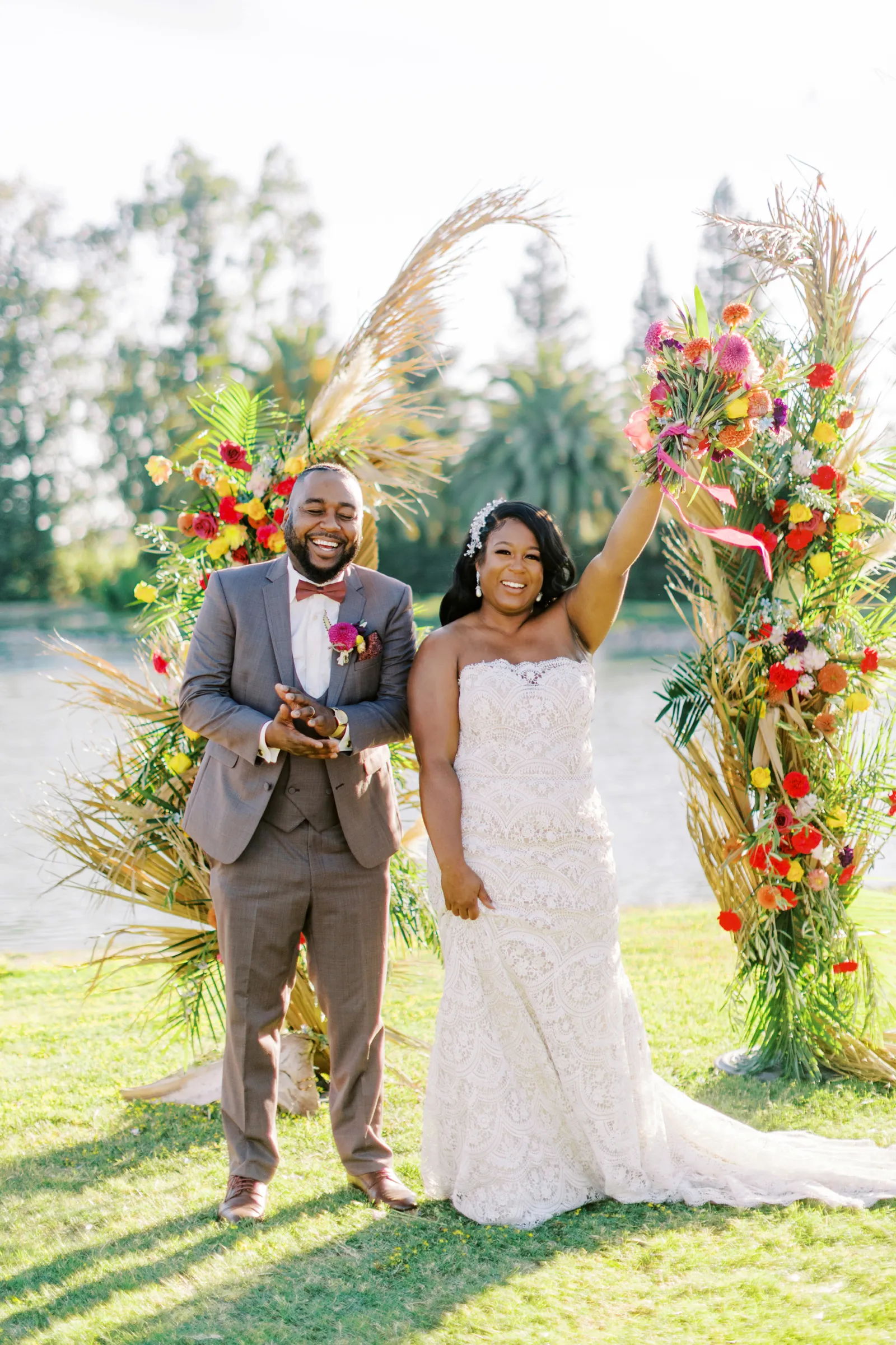 Bride and groom celebrating with hands up in the air after kissing at the altar.