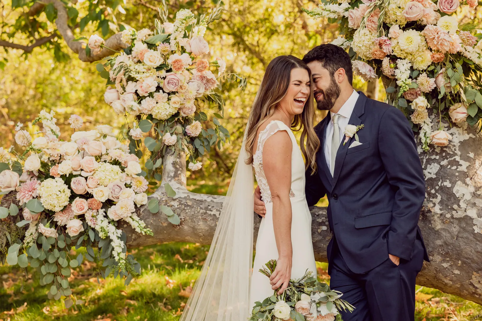 Bride laughing as her husband kisses her cheek