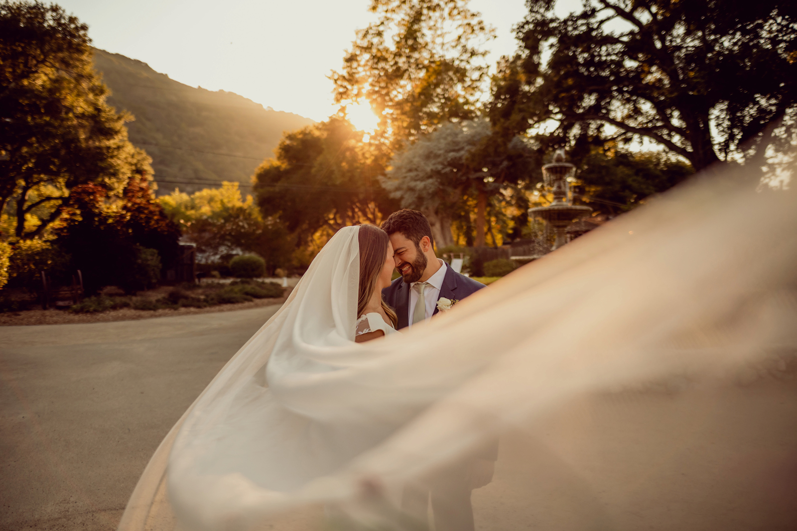 Bridal veil swishing in front of the camera while the newlyweds are about to kiss.