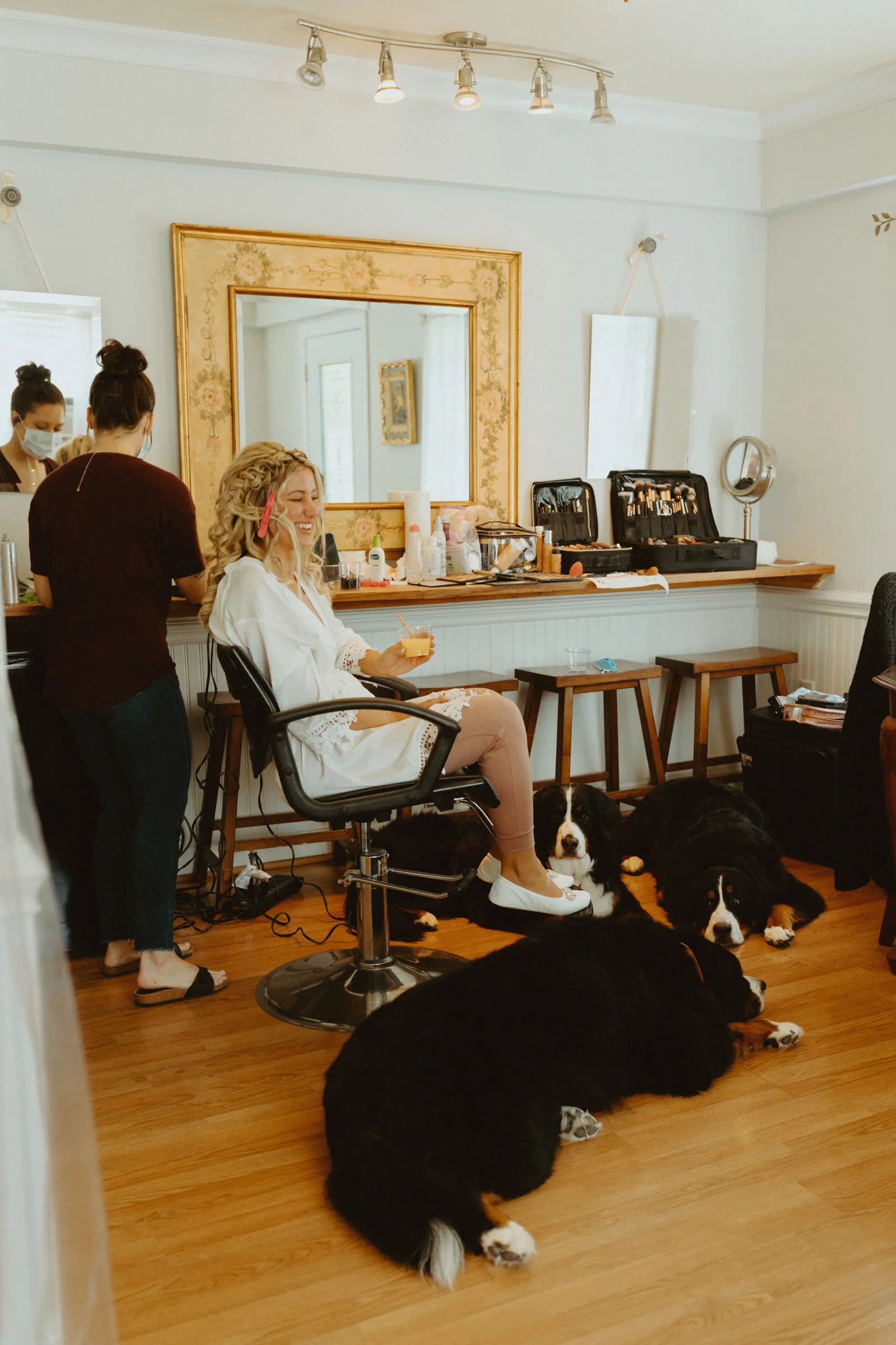 Bride getting ready with her Bernese Mountain dog laying at her feet.