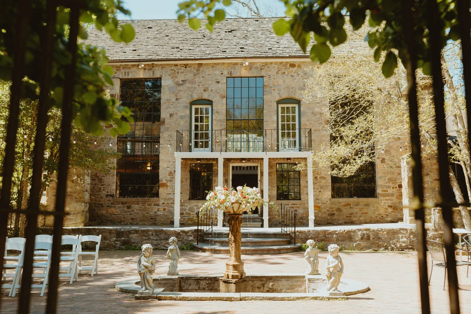 Outside photo of a mansion with a fountain in front.