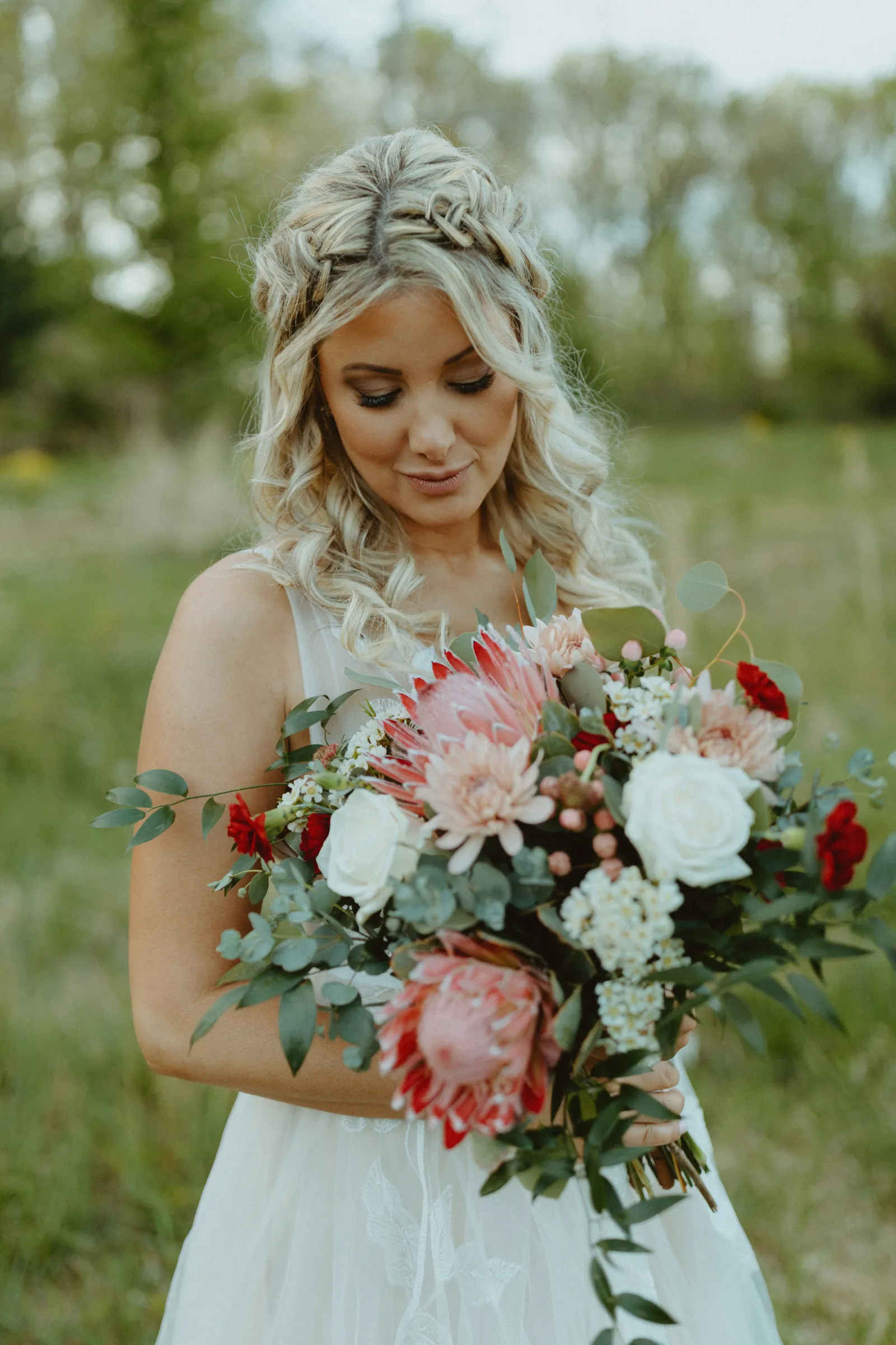 Bride smiling and looking down at her flowers.