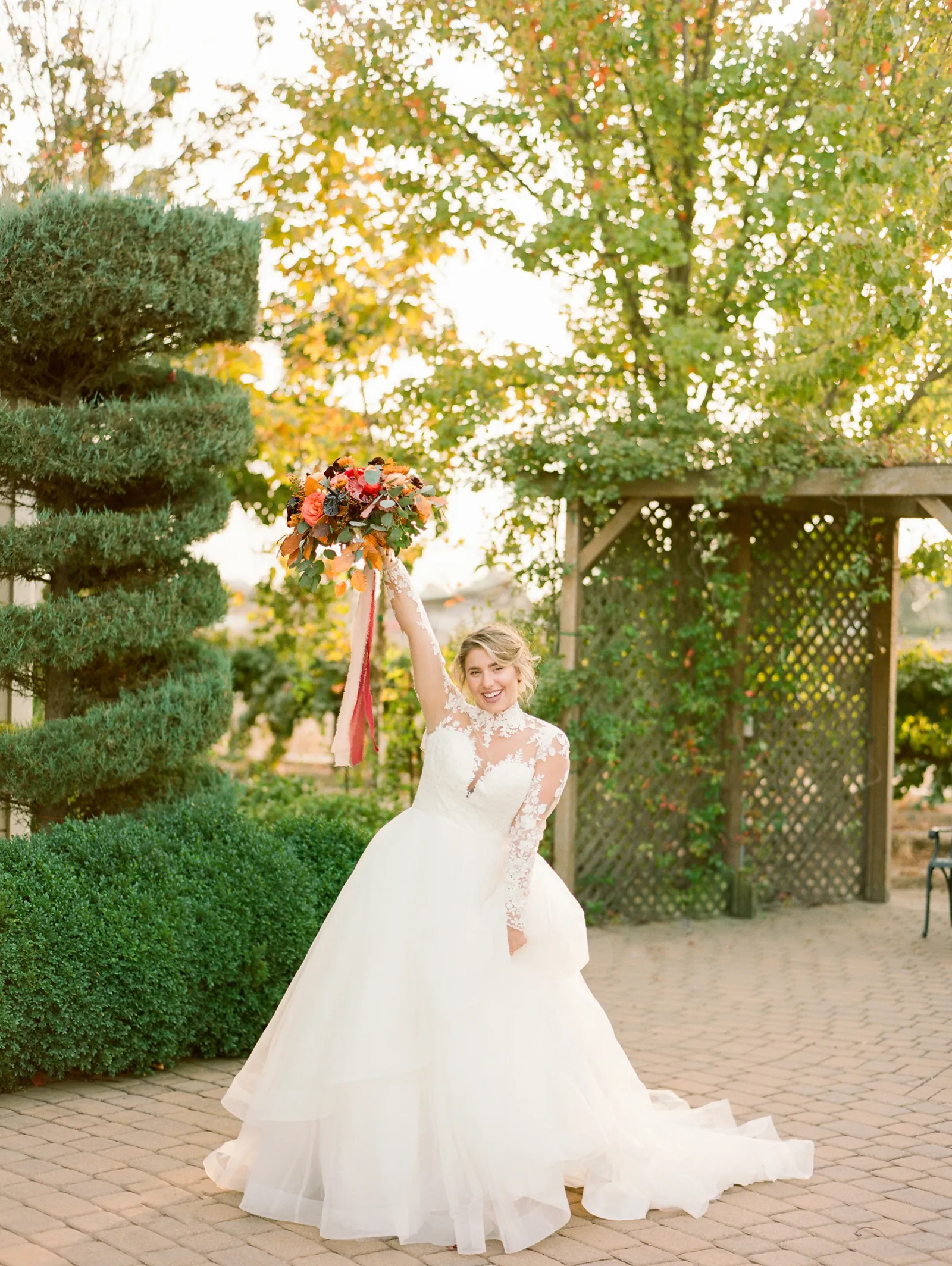 Bride celebrating, hand in the air with her bouquet