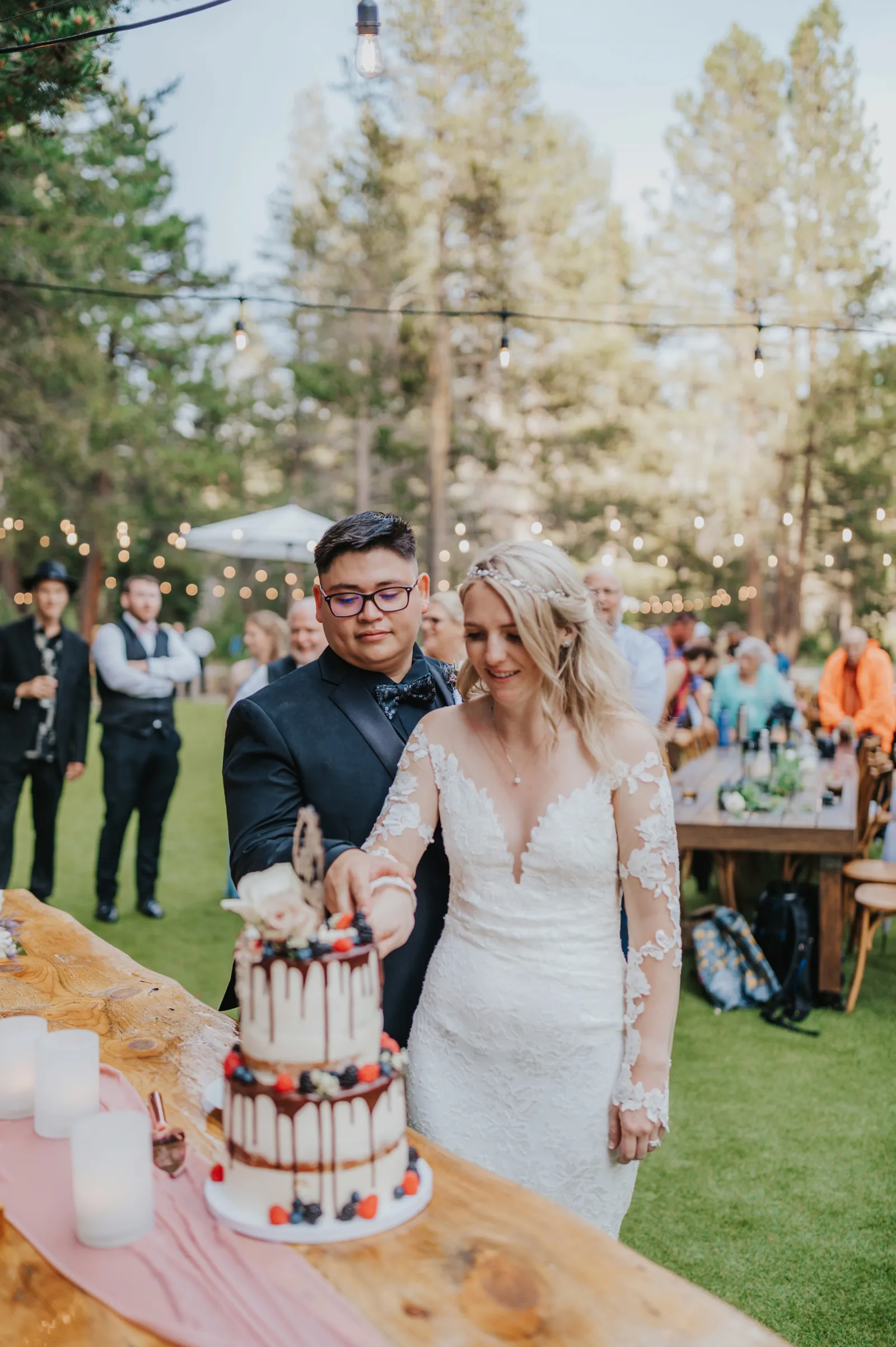 Newlyweds cutting into their wedding cake together.