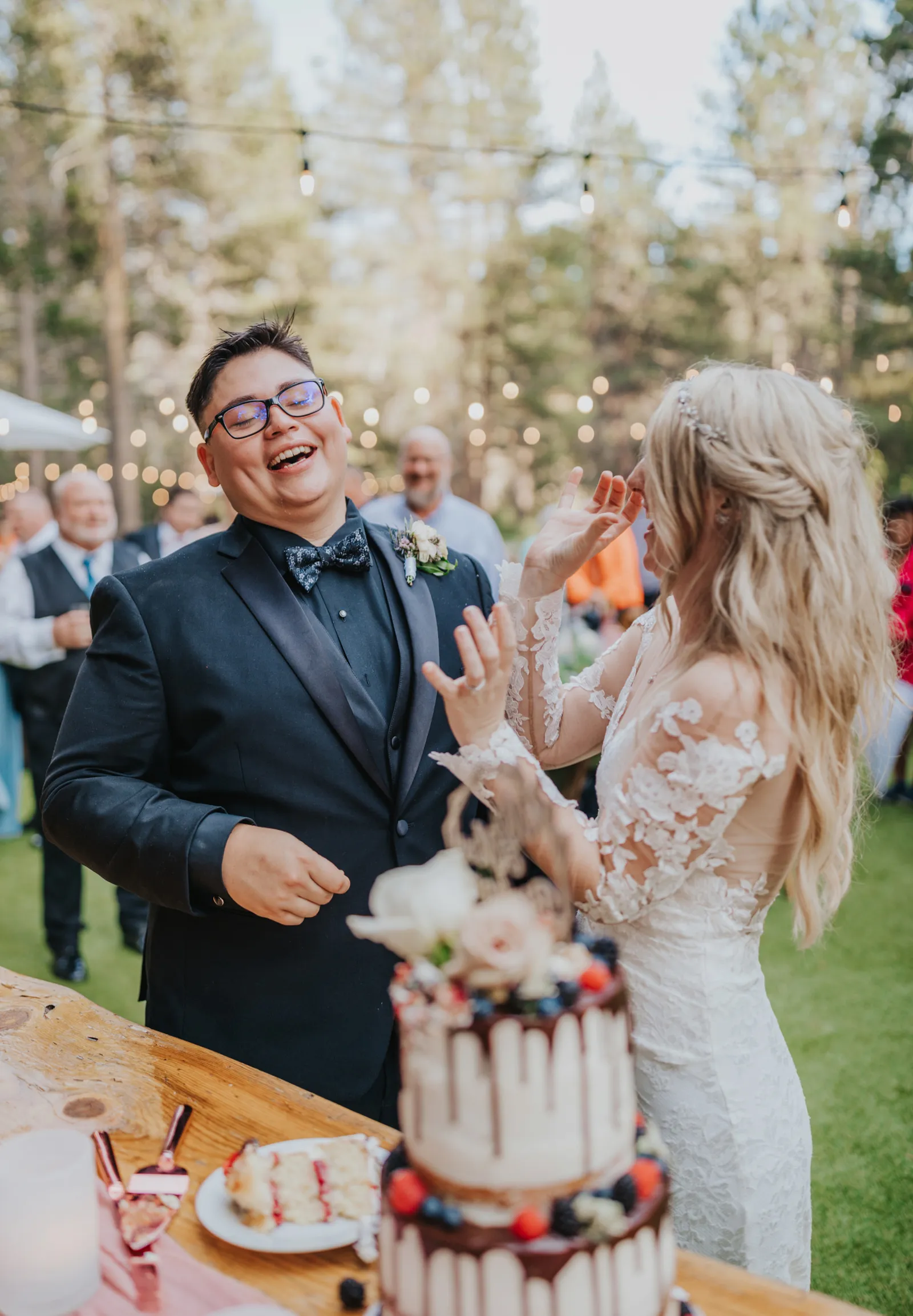 Bride and groom tasting their wedding cake and laughing.