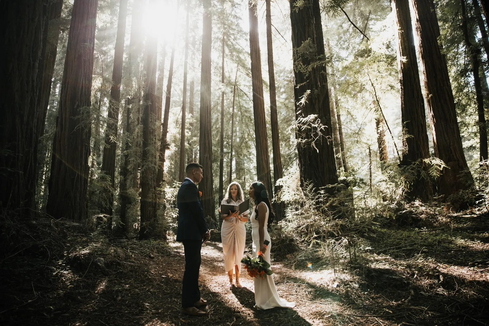 Bride and groom eloping in the forest by the ocean.