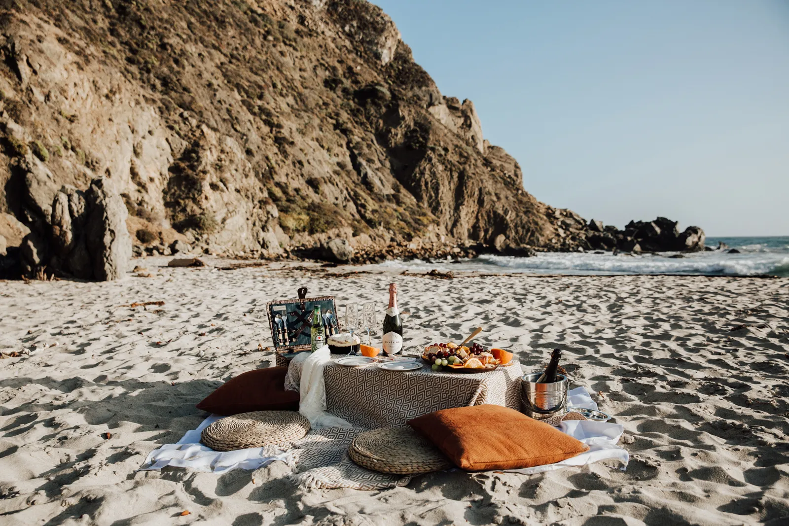 Picnic set up on the beach near the cliffside.