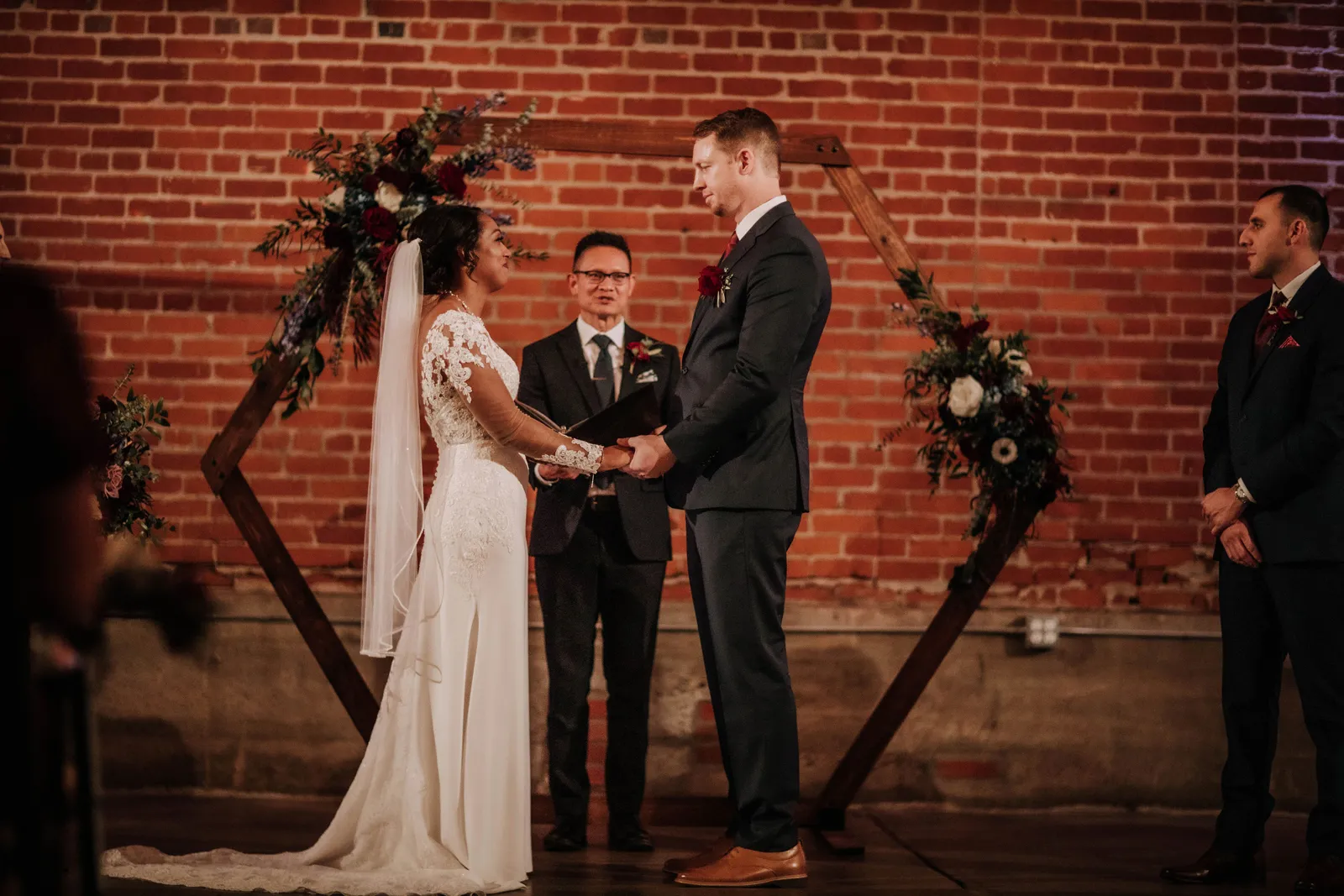 Bride and groom holding hands at the altar.