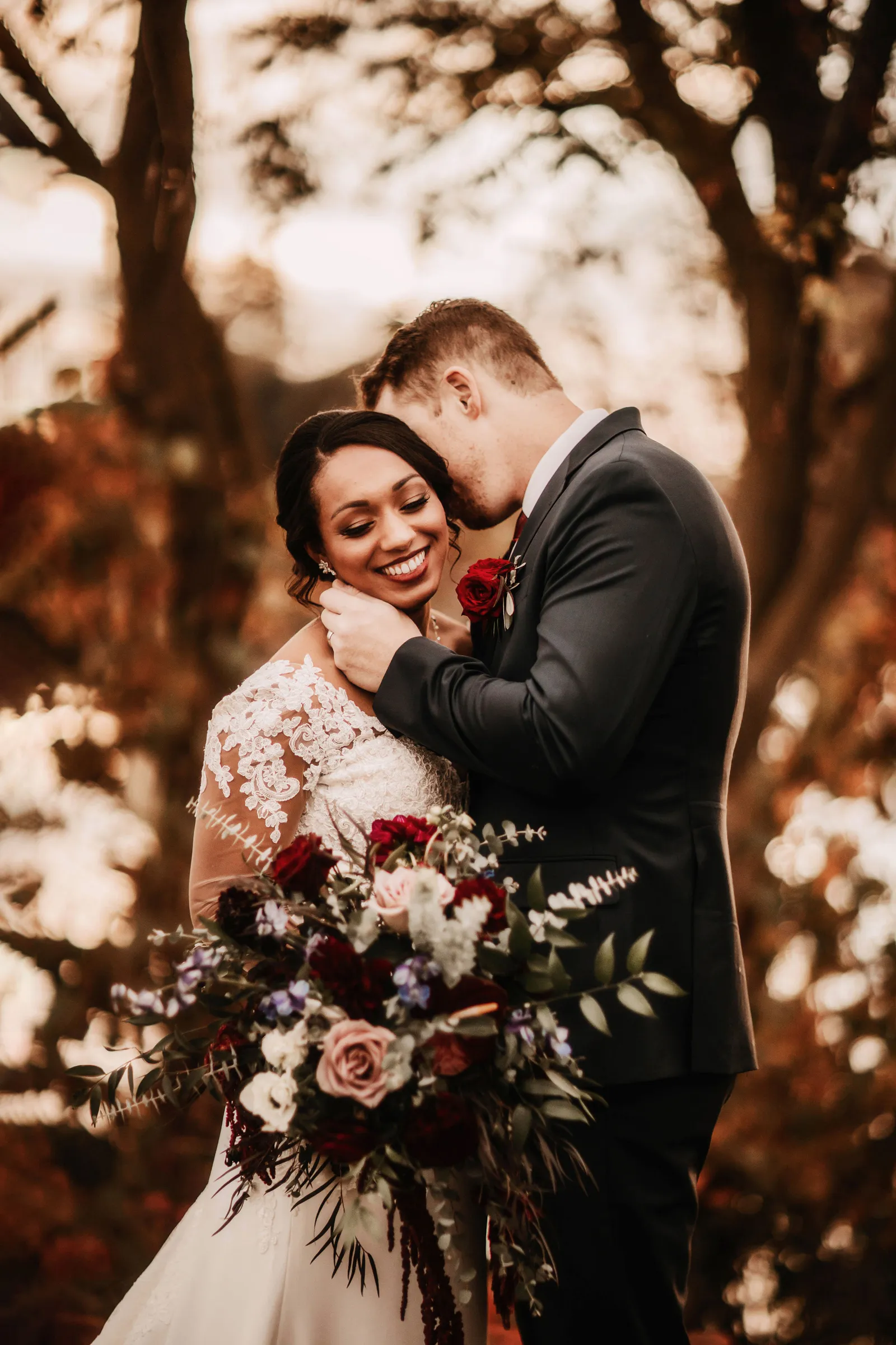 Groom holding his wife's face as she smiles.