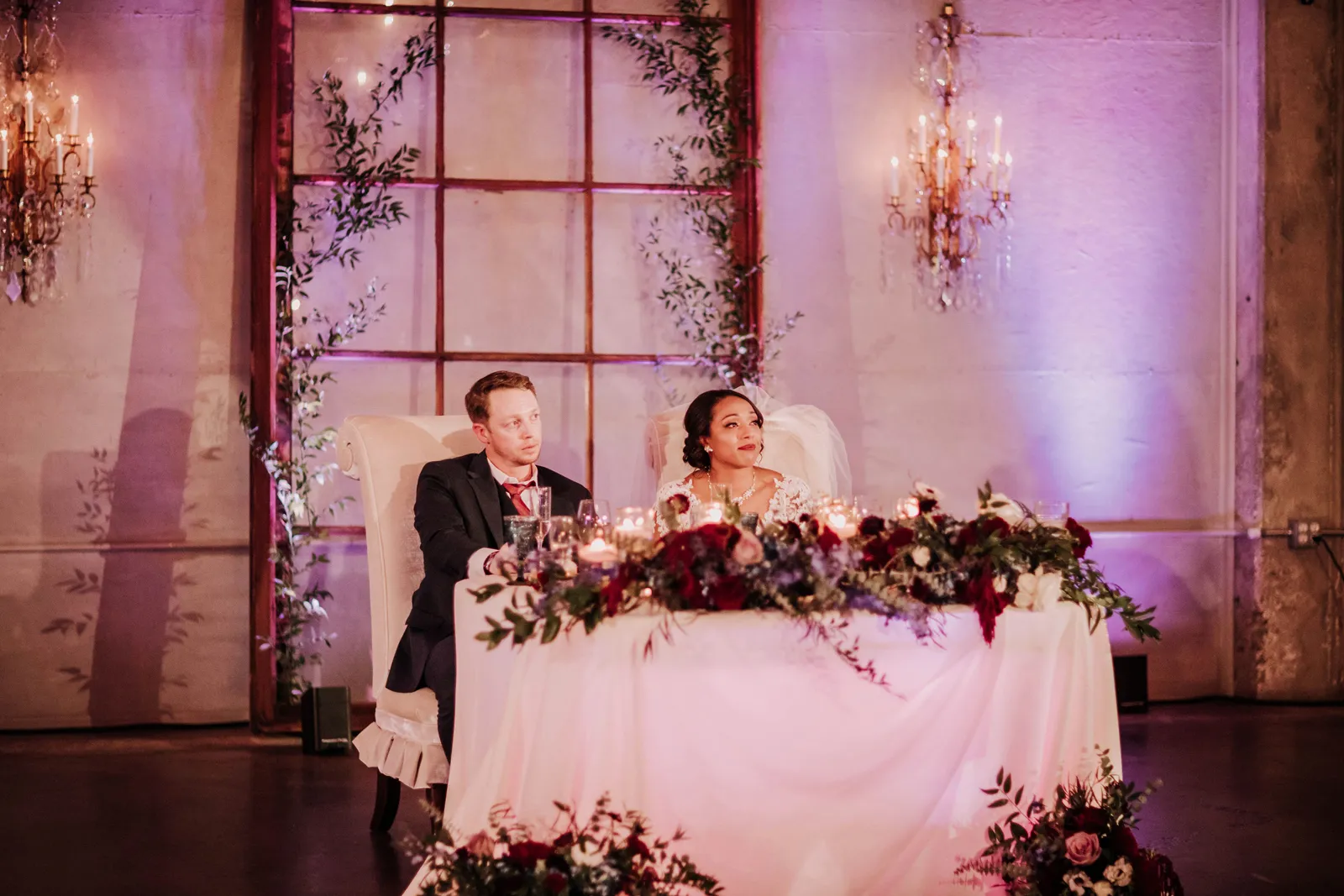 Couple sitting at their wedding table and smiling.