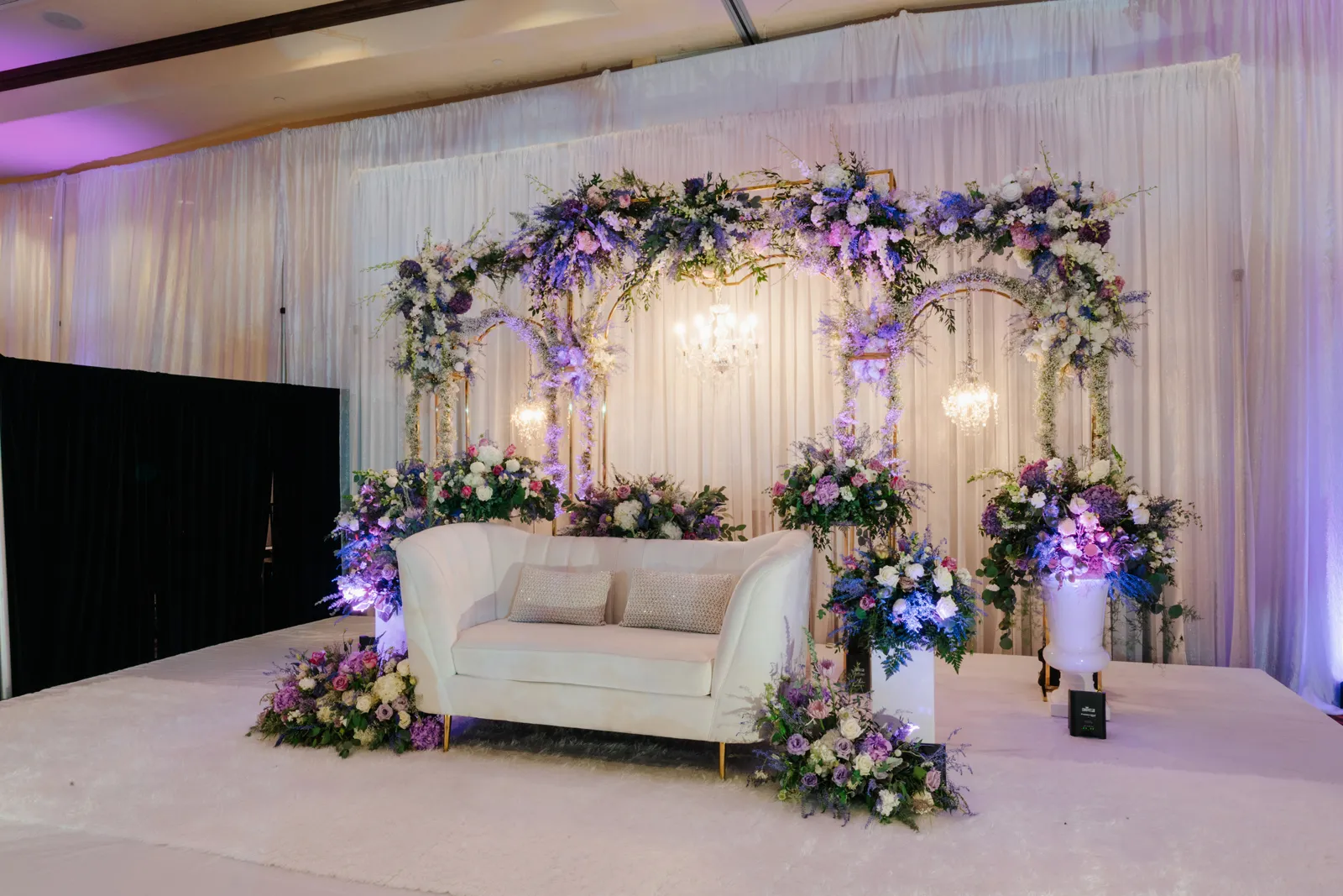 White couch surrounded by lilac flowers.