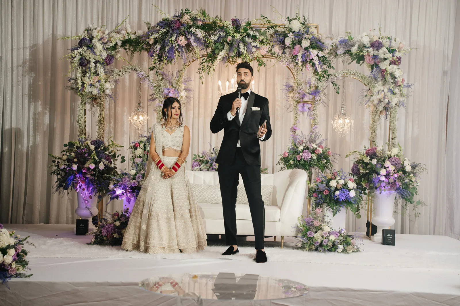 Groom making a toast while his bride listens.