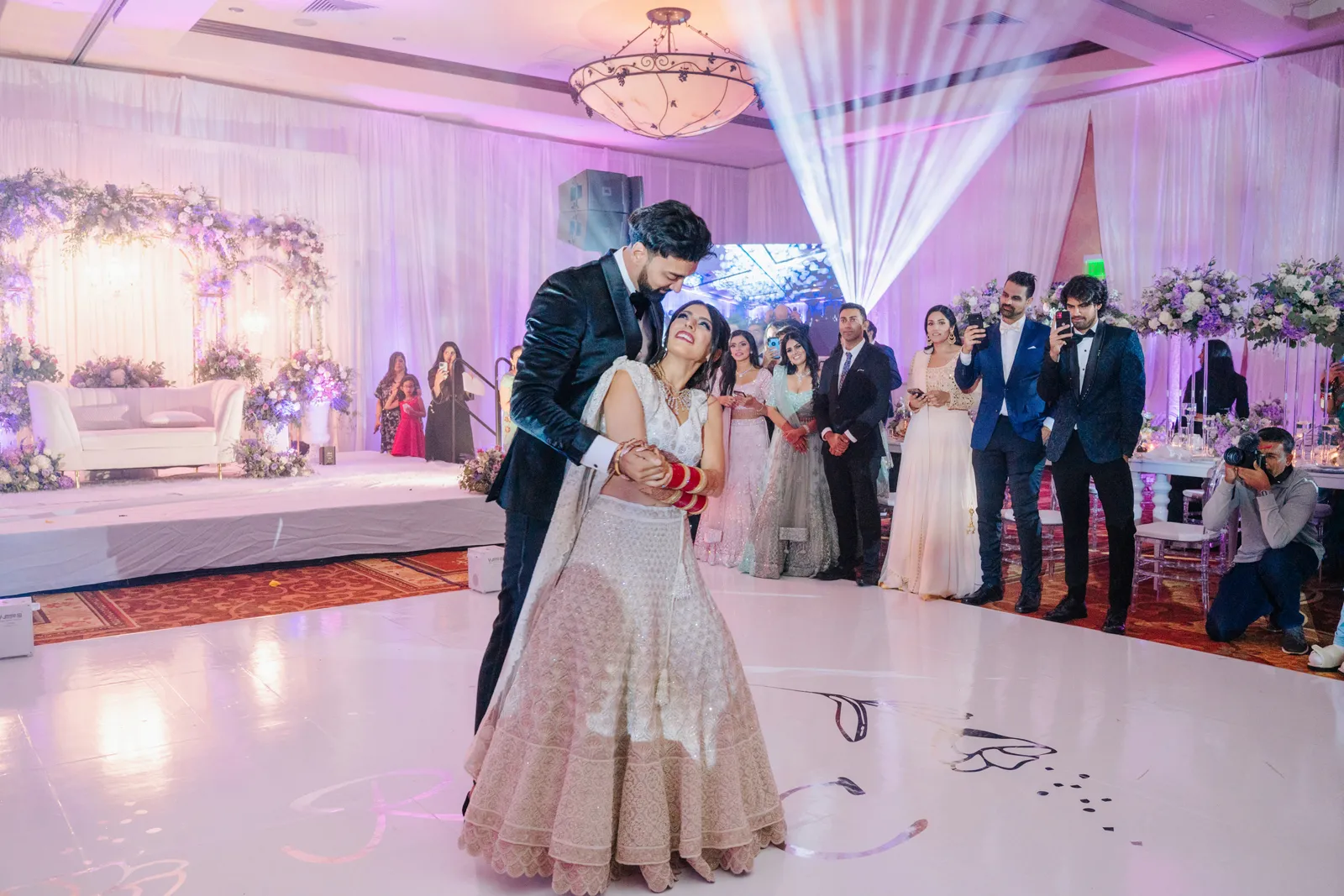 Groom and bride dancing together and smiling.