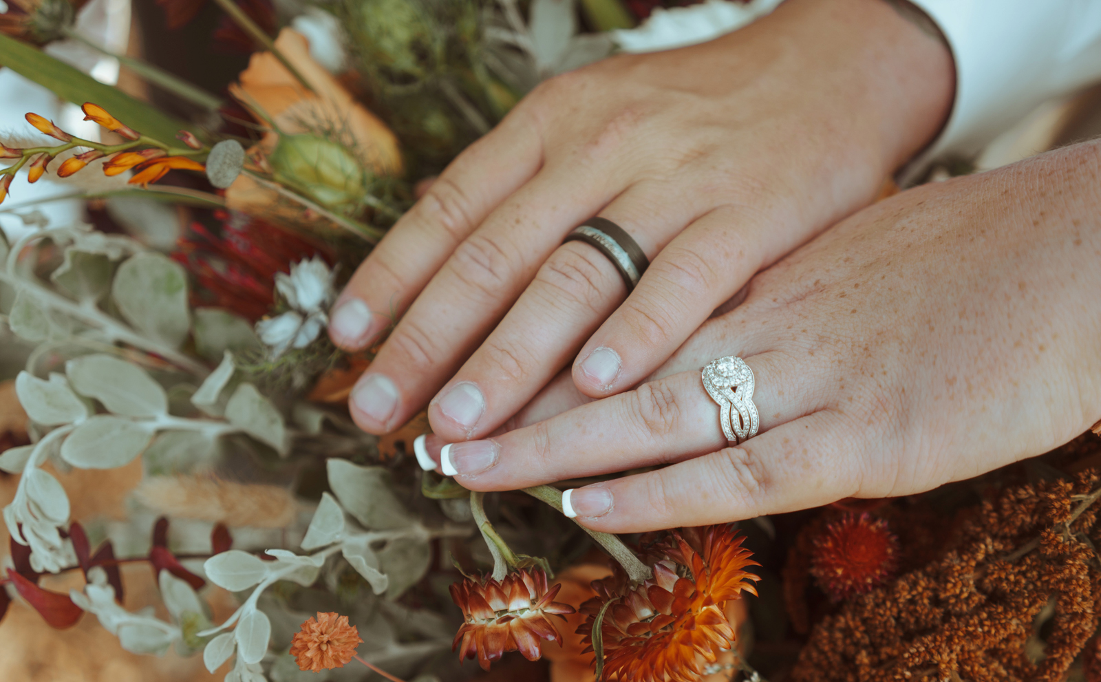 Close up of the bride and groom's ring fingers.