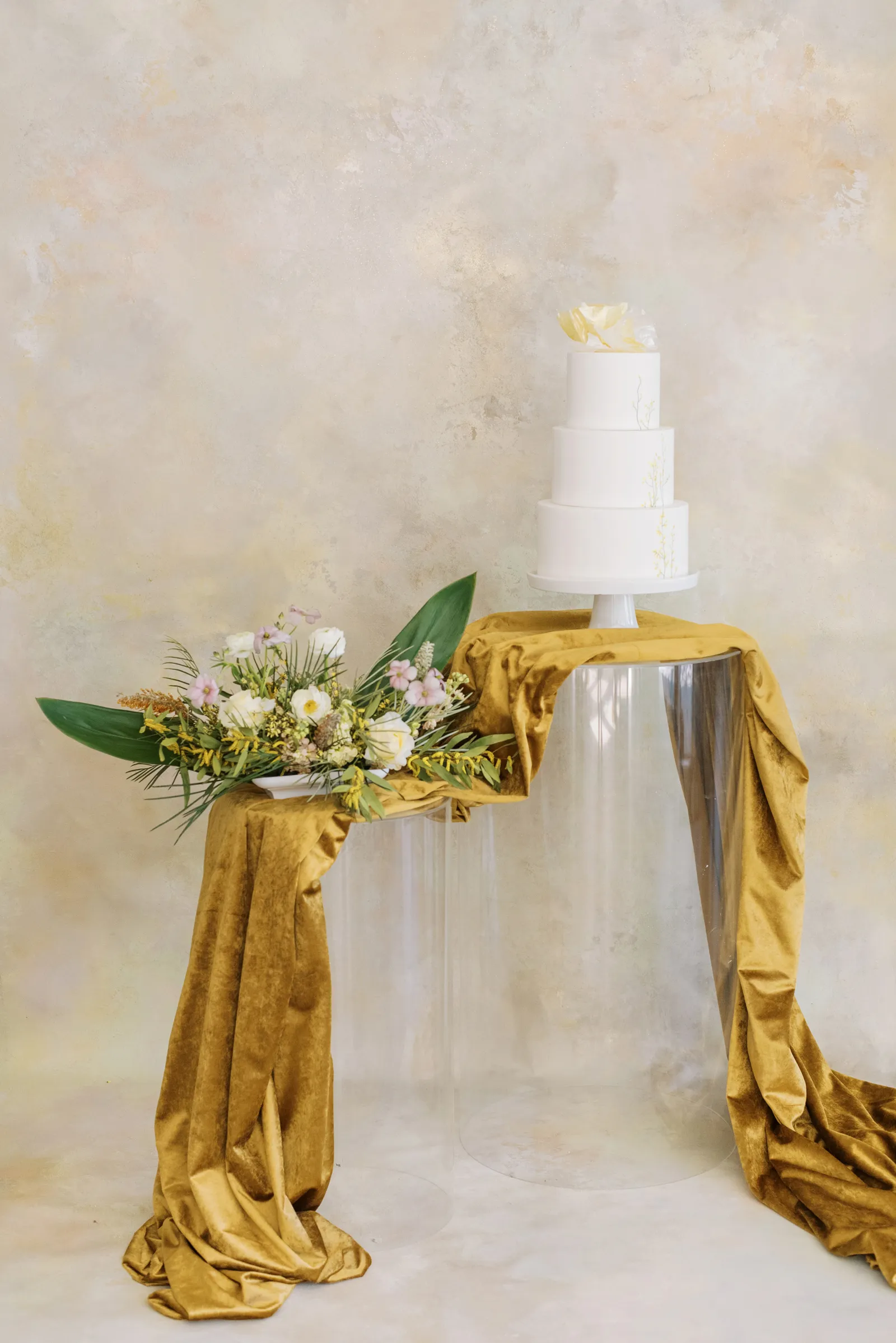 White cake with a pale background sitting on a table with a golden ribbon.