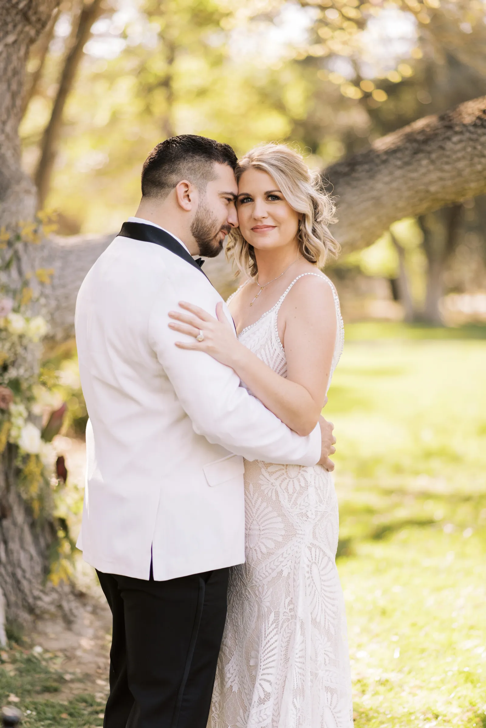 Bride smiling over his groom's shoulder.