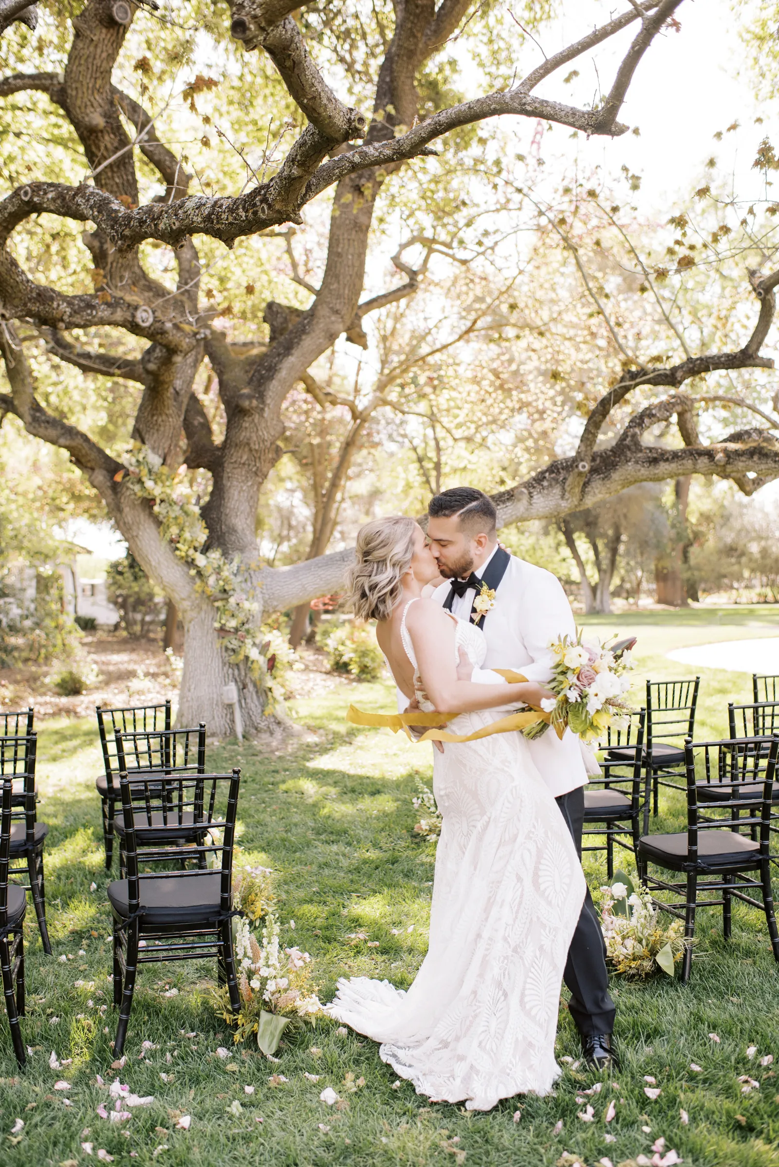 Groom kissing his bride at the end of the aisle.