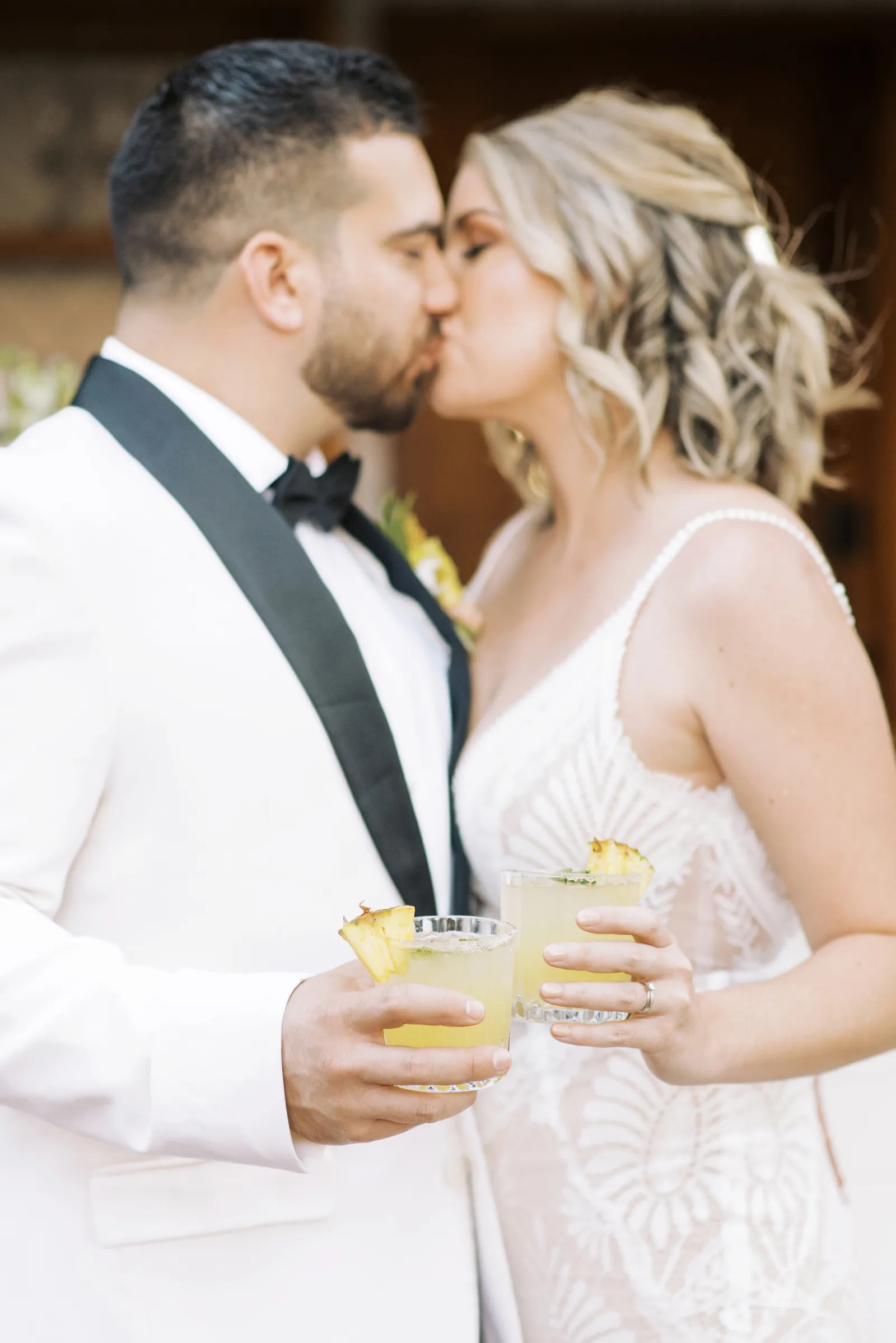 Bride and groom kissing as they cheers.