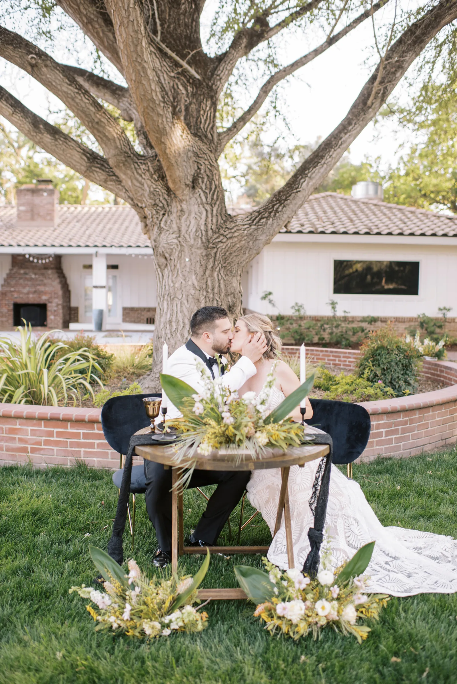 Bride and groom kissing at a small round table for the two of them. 