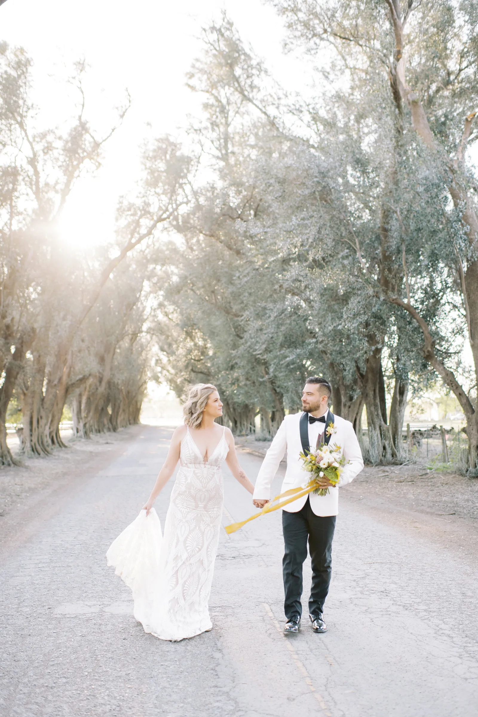 Bride and groom holdings hands and walking down the street.