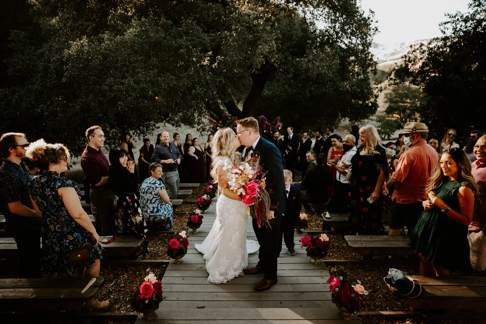 Bride and groom kissing after walking down the aisle together.