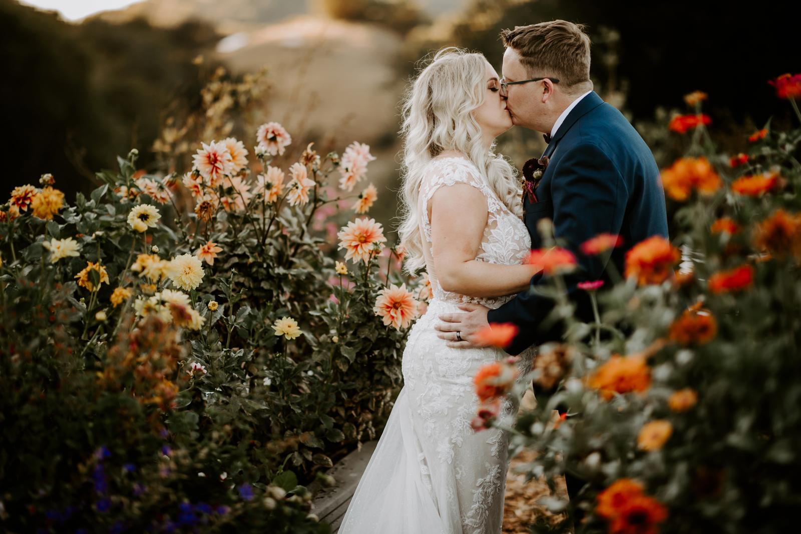 Bride and groom kissing in the flower garden.