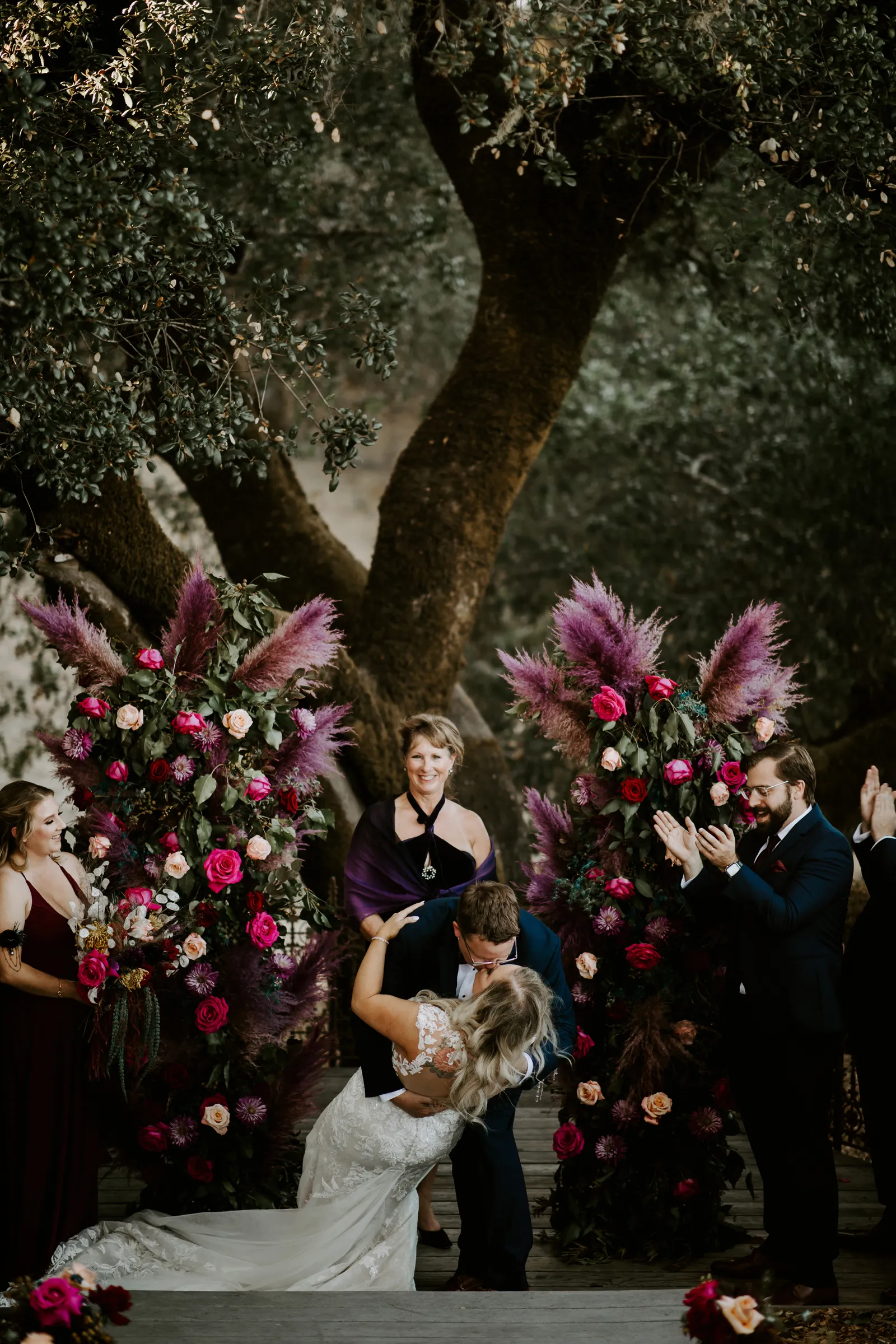 Groom dipping his bride and kissing her at the altar.