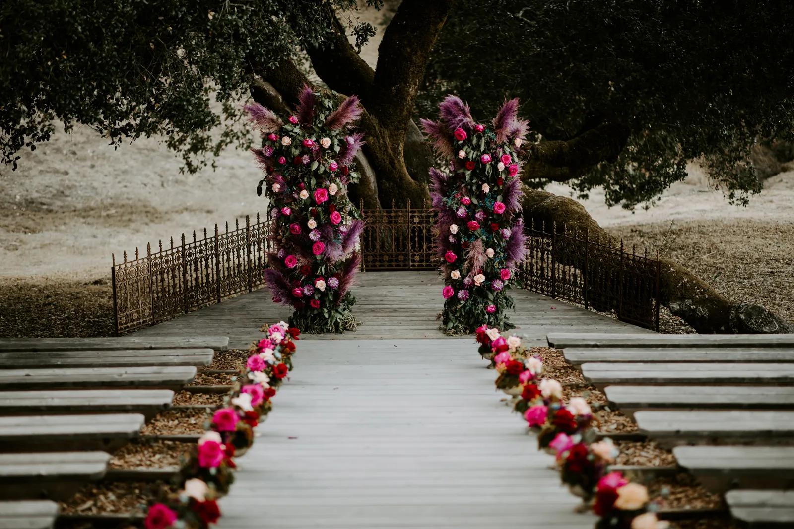 Empty aisleway leading to two vertical flower arches.