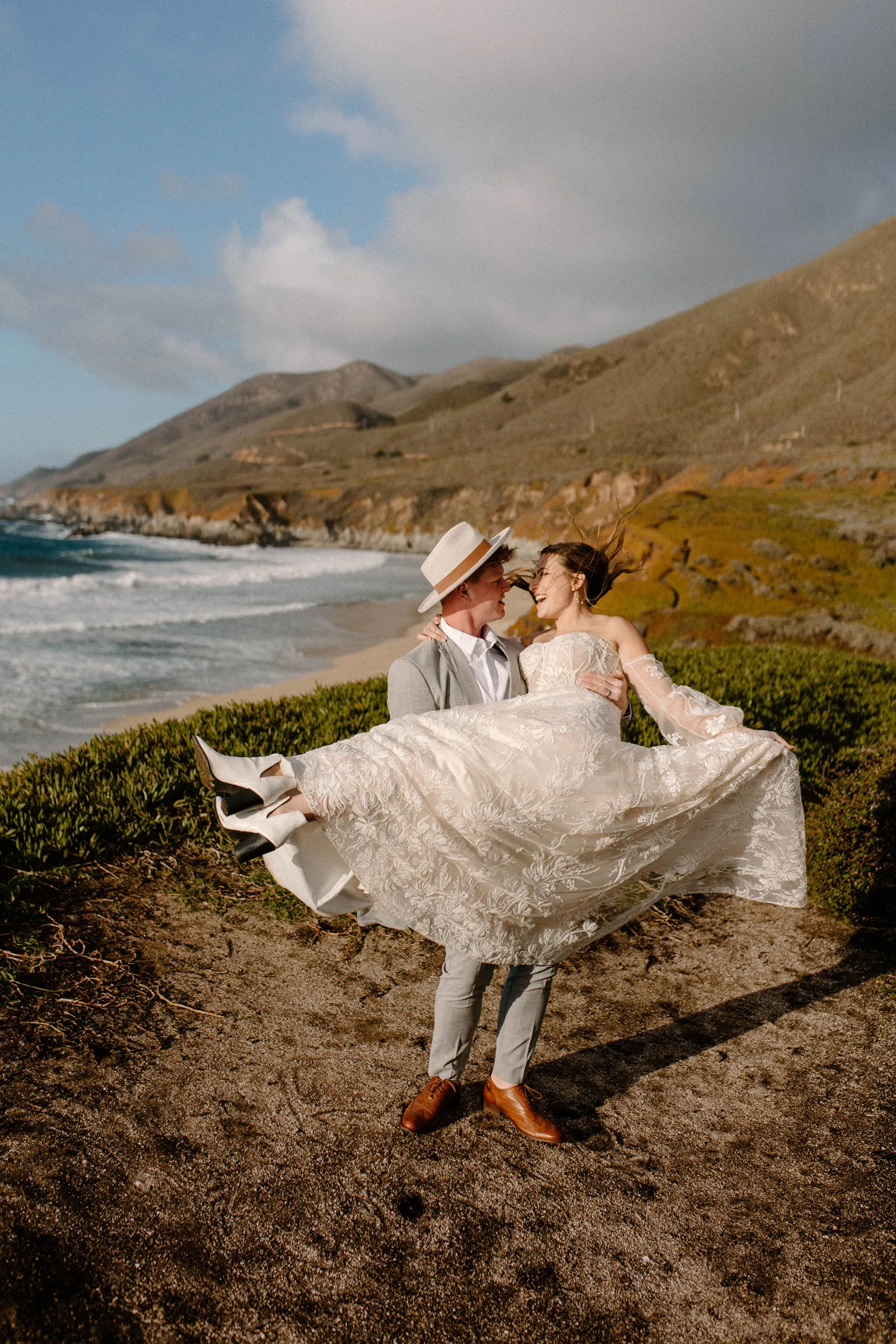 Groom holding his bride in his arms and dancing with her.