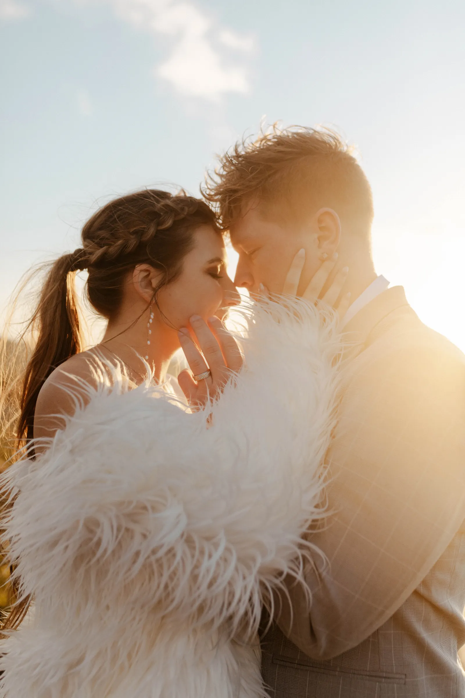 Sun setting as bride and groom hold each other close.