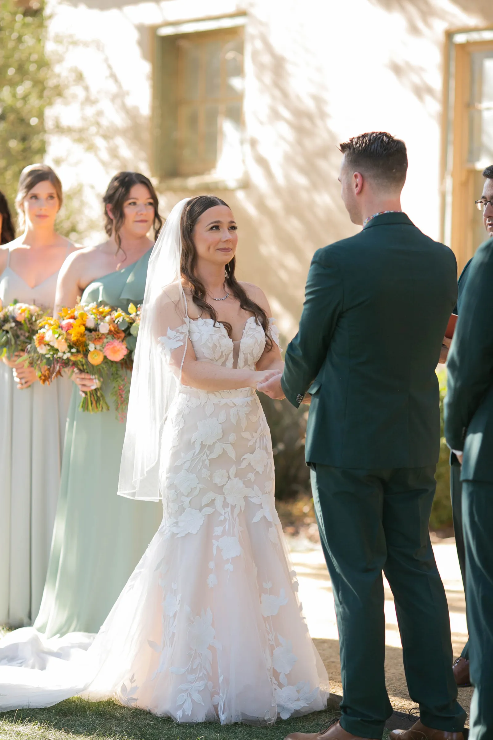 Bride and groom holding hands at the altar while the officiant speaks.