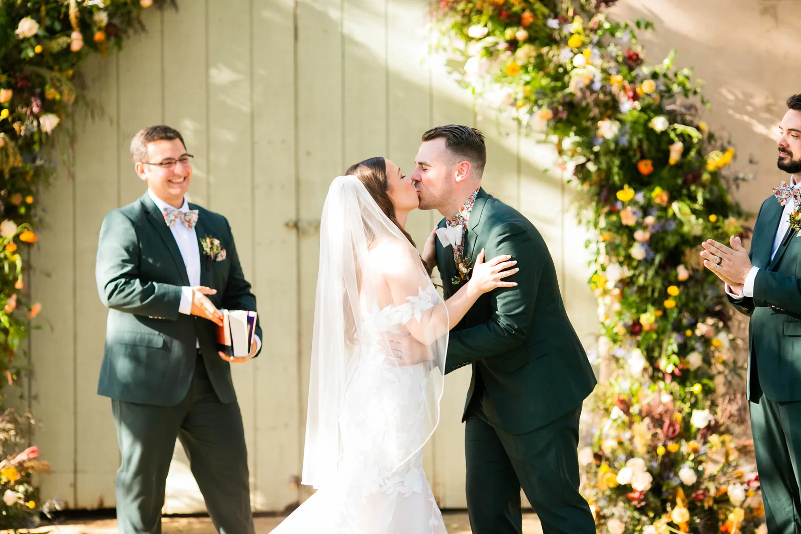 Groom kissing his bride at the altar.