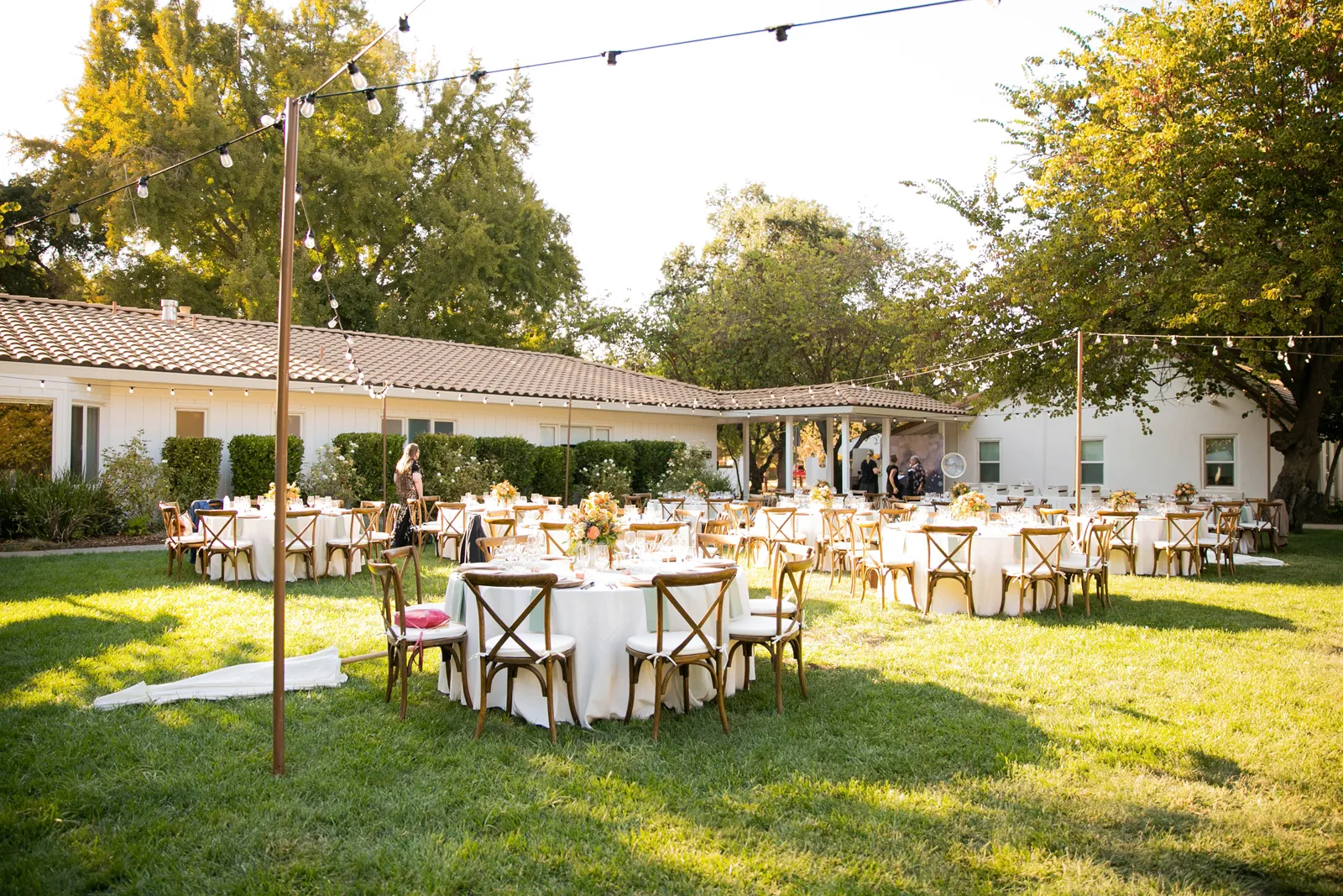 Reception venue outside with white circle tables.