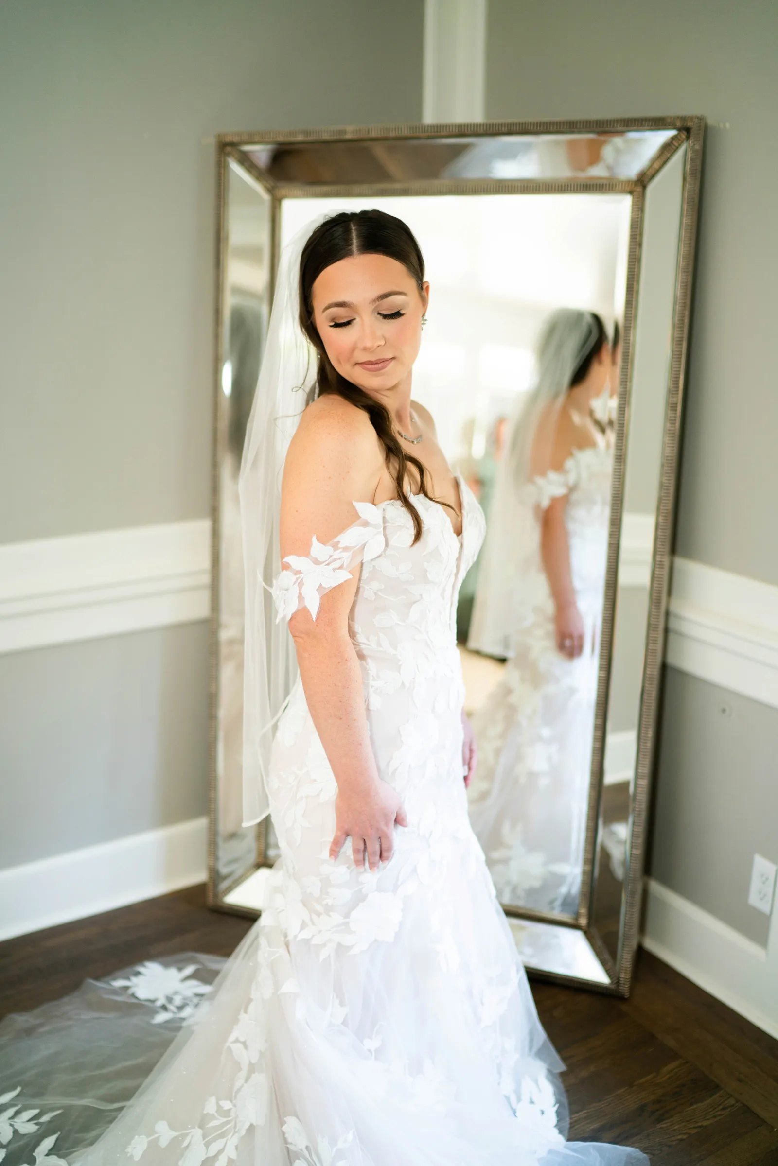 Bride to be looking down at her dress as she's getting dressed.