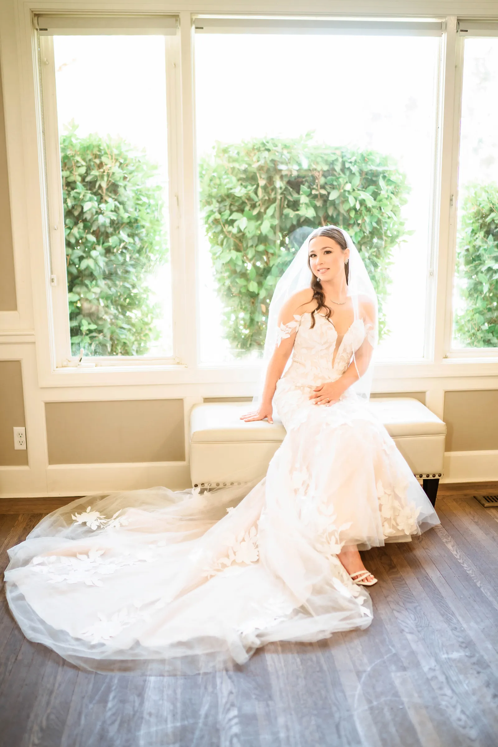 Bride smiling while she sits down in her wedding dress.