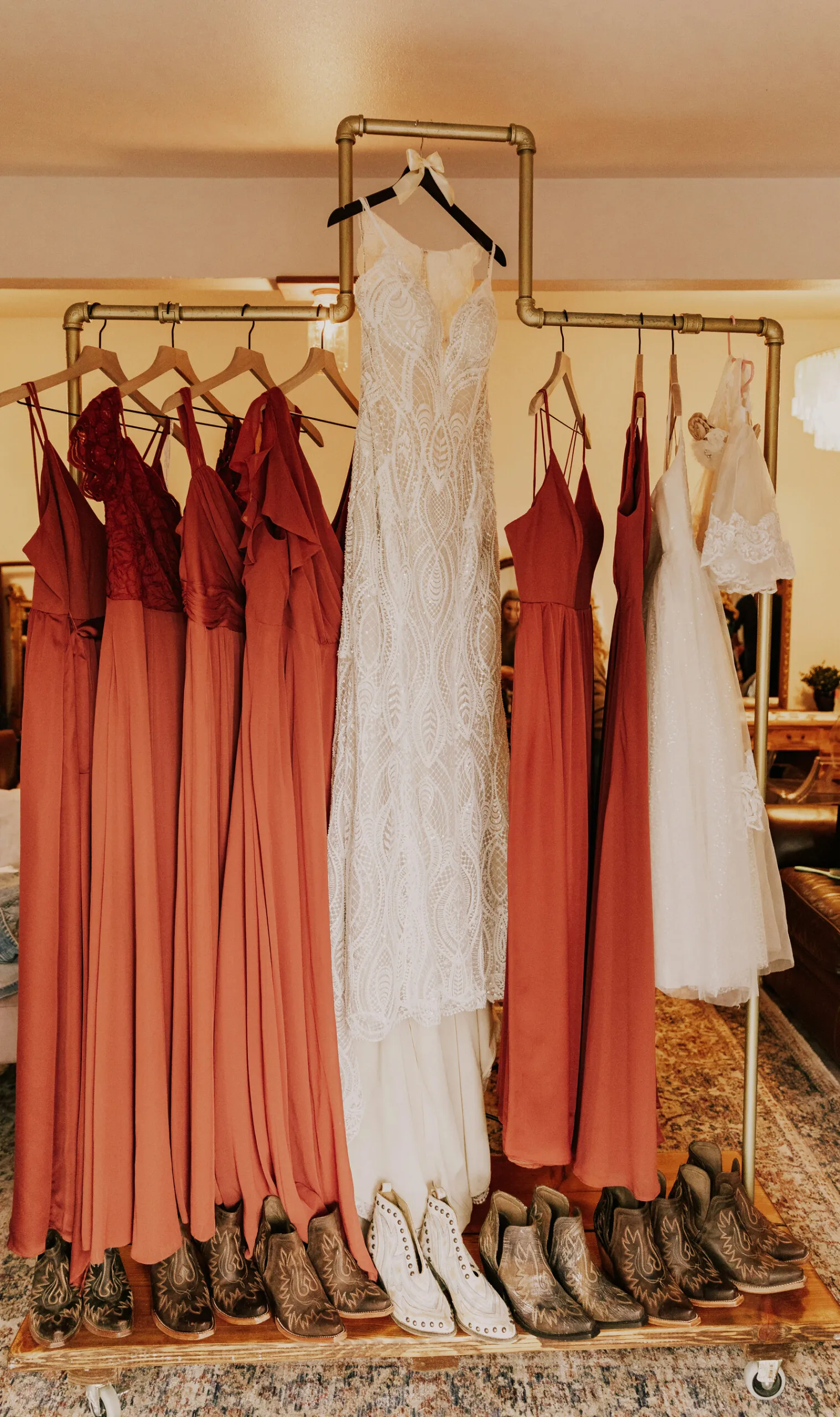 Bridal gown and bridesmaids dresses hanging up on a rack.