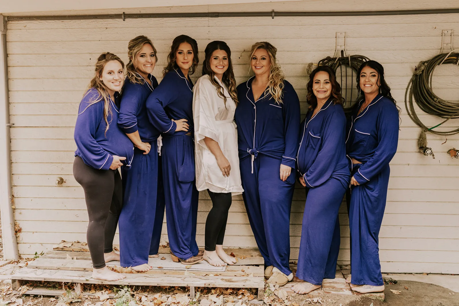 Bride and her bridesmaids smiling and posing for the camera.